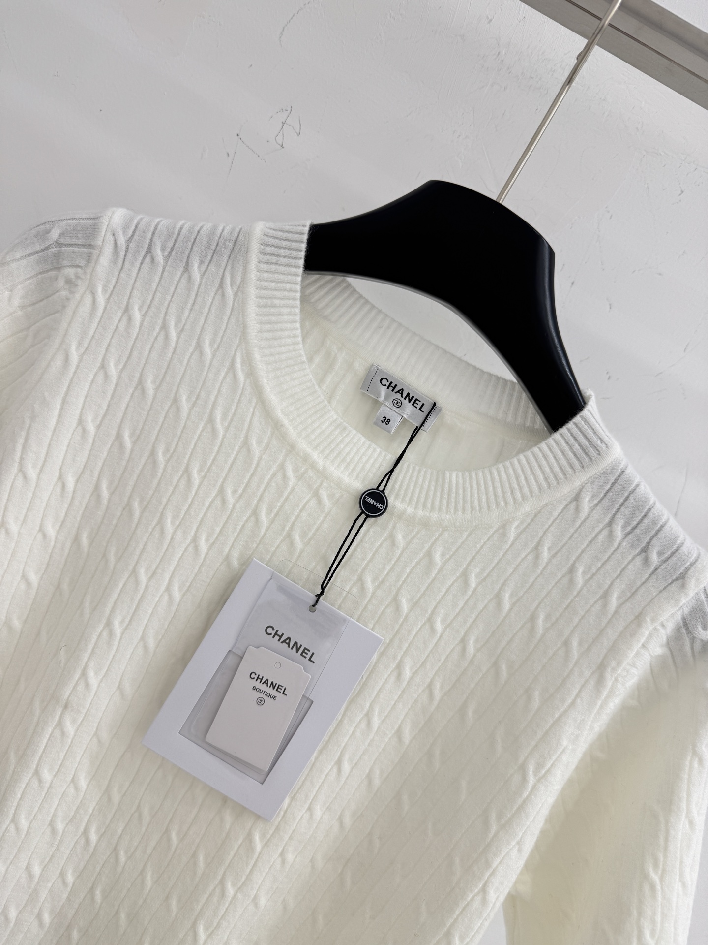 Chanel 纯色简约设计，麻花针织纹理，清爽舒适，适合早春穿搭。字母刺绣图案，增添细节感