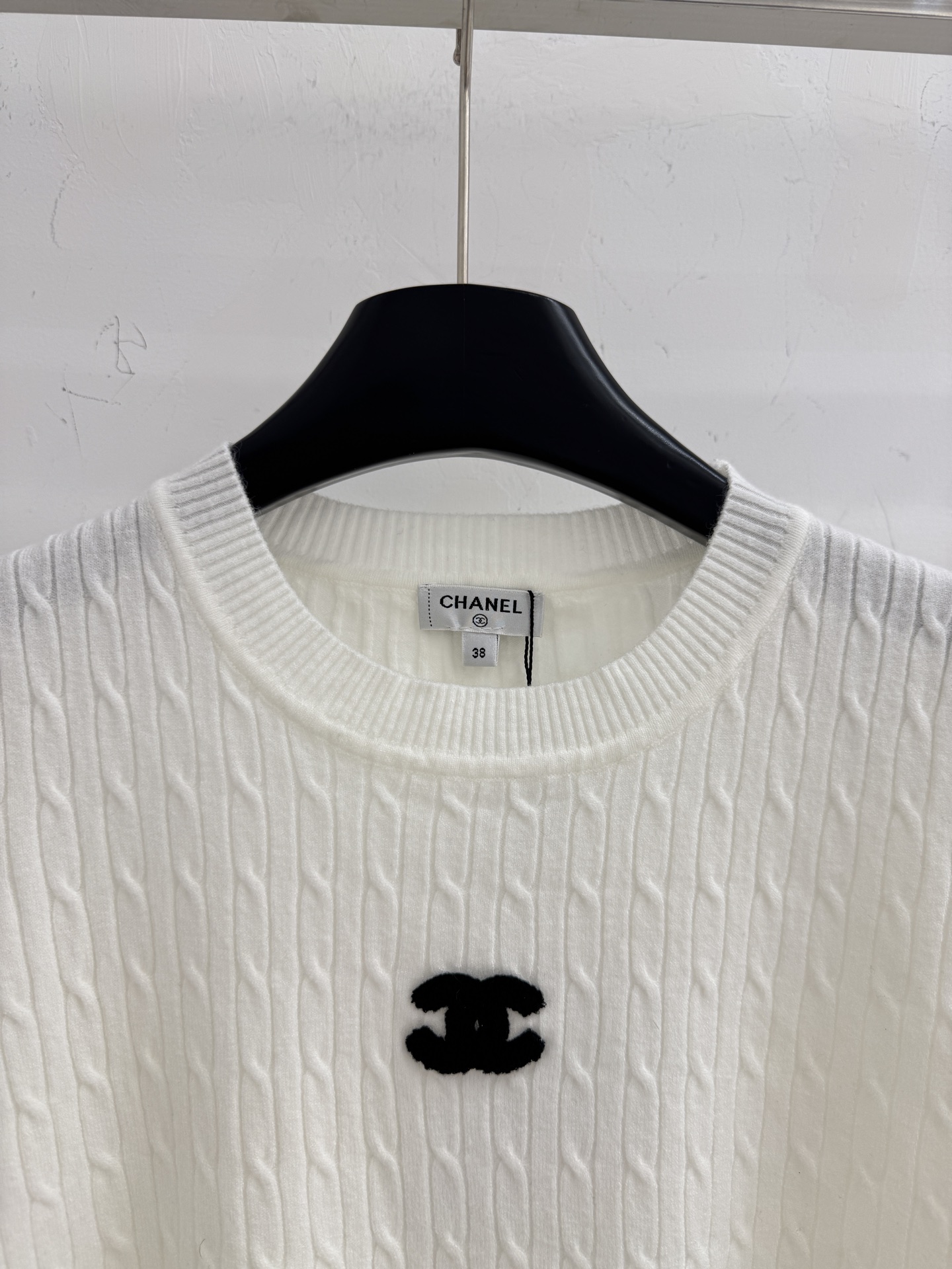 Chanel 纯色简约设计，麻花针织纹理，清爽舒适，适合早春穿搭。字母刺绣图案，增添细节感
