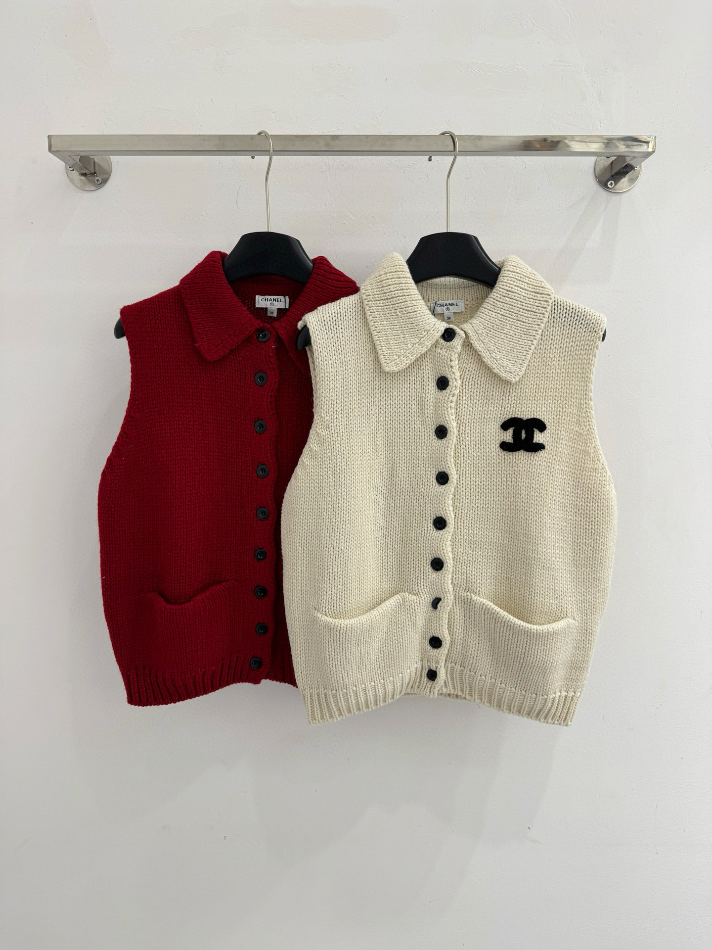 Chanel 无袖坎肩版型，翻领设计，前襟单排黑色圆形纽扣闭合，两侧各有一个对称口袋，简约优雅