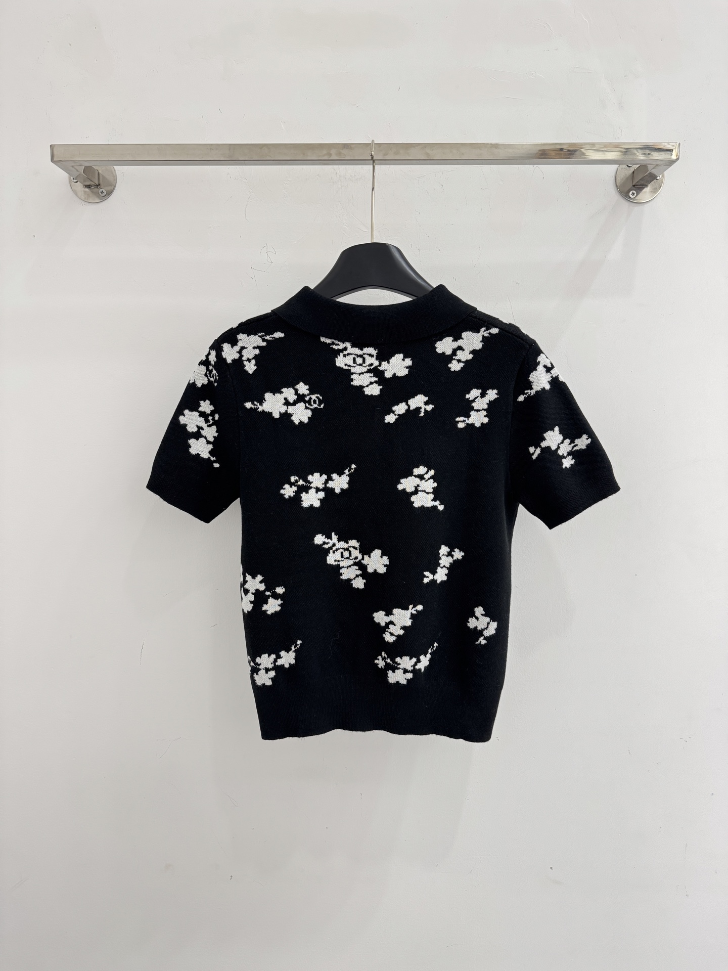 Chanel 短袖针织Polo衫，布满白色花卉图案，领口白色纽扣点缀，提花造型小巧 ，增添自然清新感