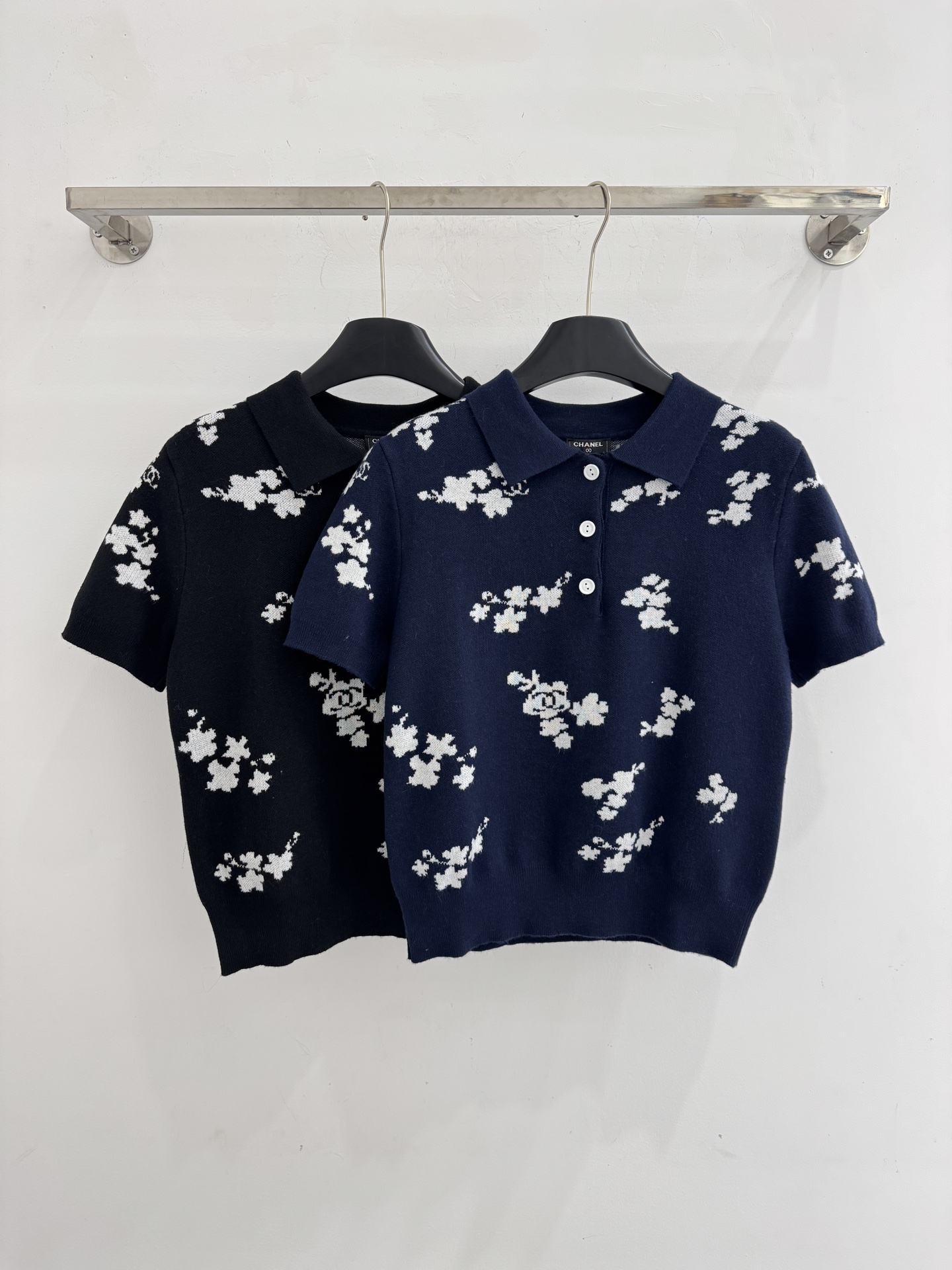 Chanel 短袖针织Polo衫，布满白色花卉图案，领口白色纽扣点缀，提花造型小巧 ，增添自然清新感