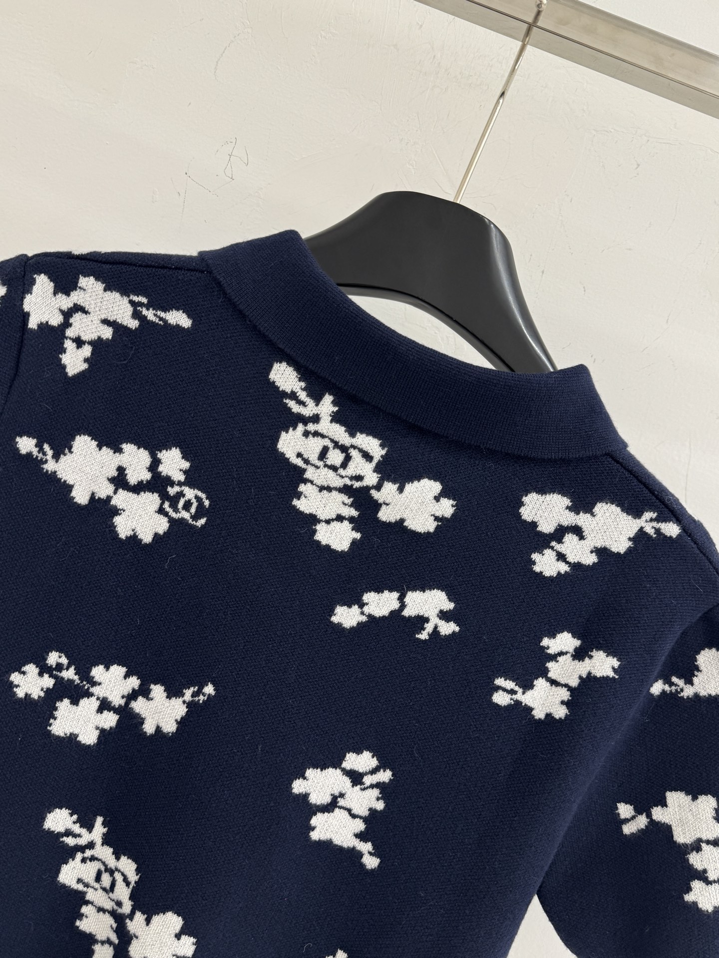 Chanel 短袖针织Polo衫，布满白色花卉图案，领口白色纽扣点缀，提花造型小巧 ，增添自然清新感