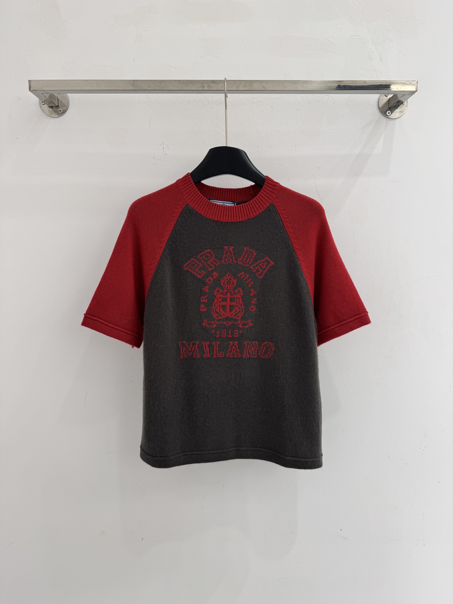 Unknown 刺绣拼色针织衫‌，与现代感，撞色对比鲜明，胸前绣有‌字母及徽章图案‌，休闲百搭