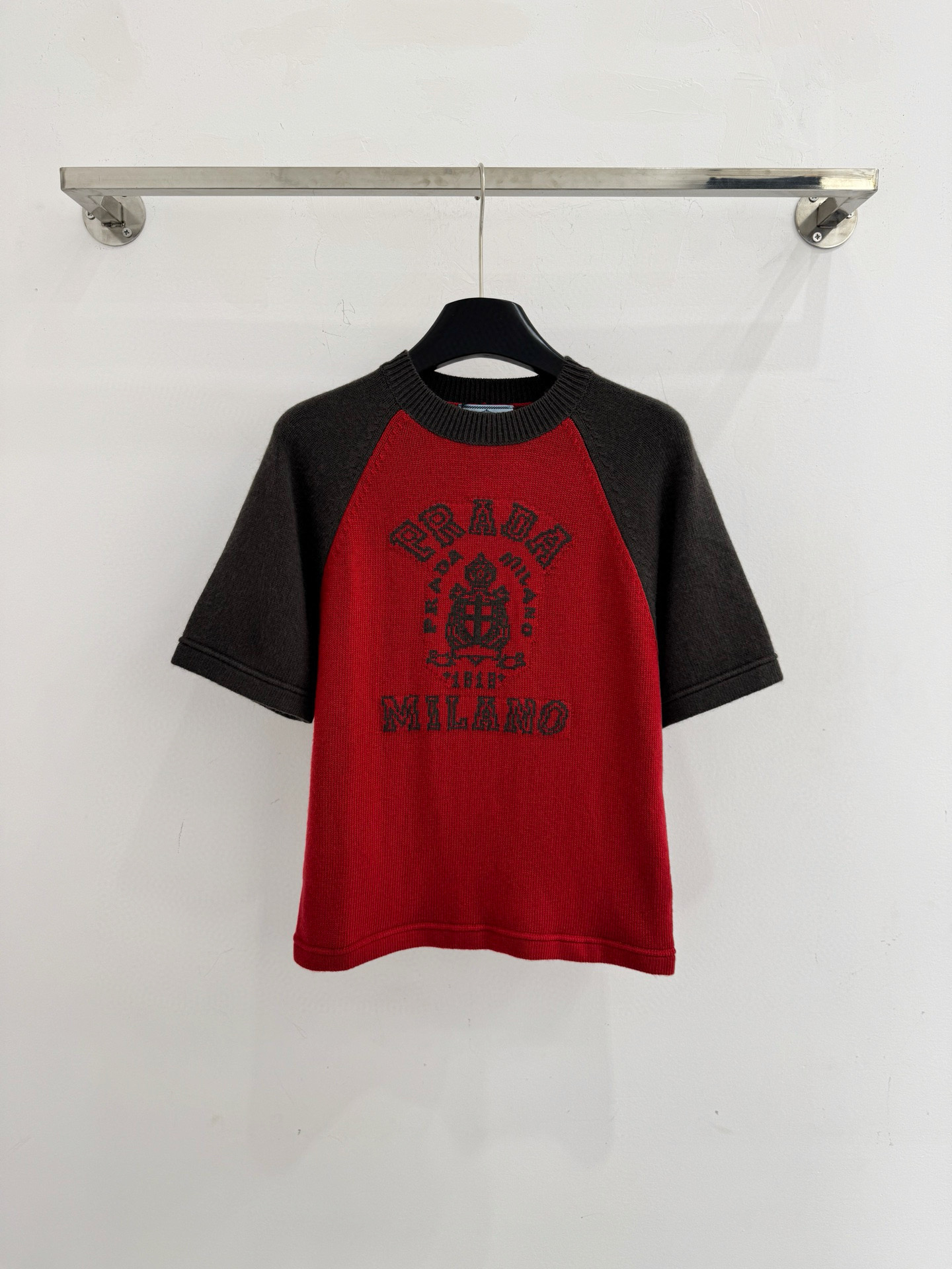 Unknown 刺绣拼色针织衫‌，与现代感，撞色对比鲜明，胸前绣有‌字母及徽章图案‌，休闲百搭