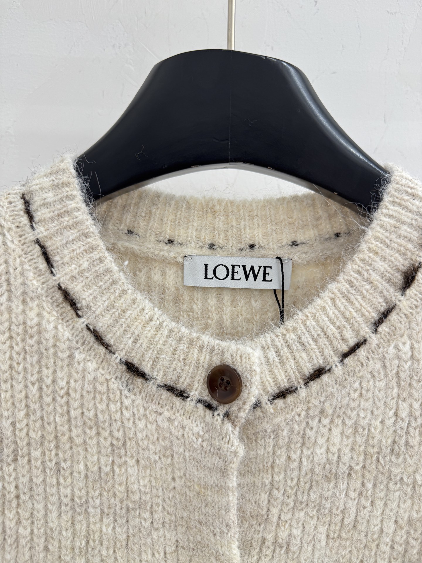 Loewe 无袖坎肩版型，翻领设计，前襟单排圆形纽扣闭合，两侧各有一个对称口袋，简约优雅