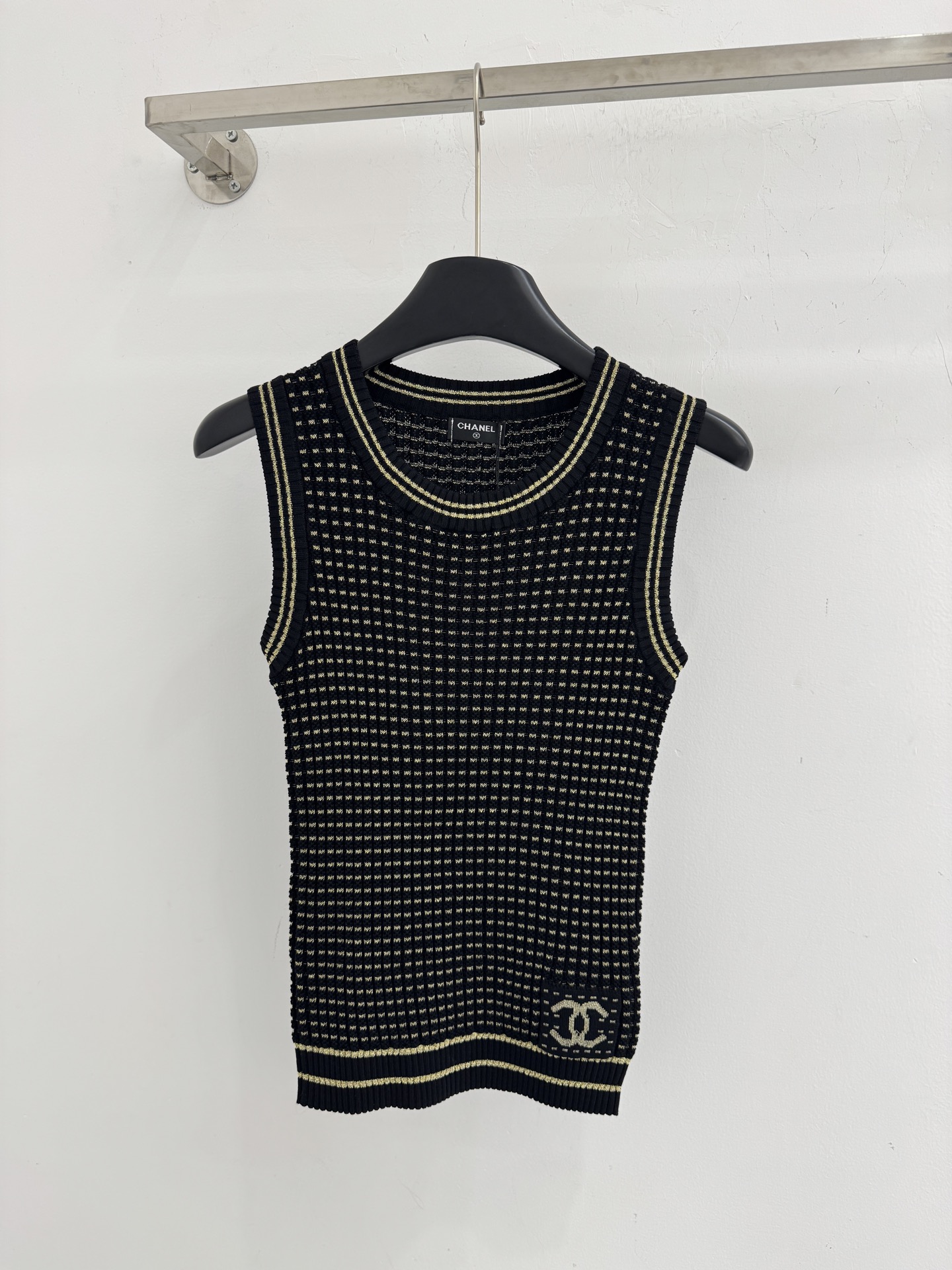 Chanel 无袖圆领设计，领口、下摆处有撞色条纹包边，简约又 。H