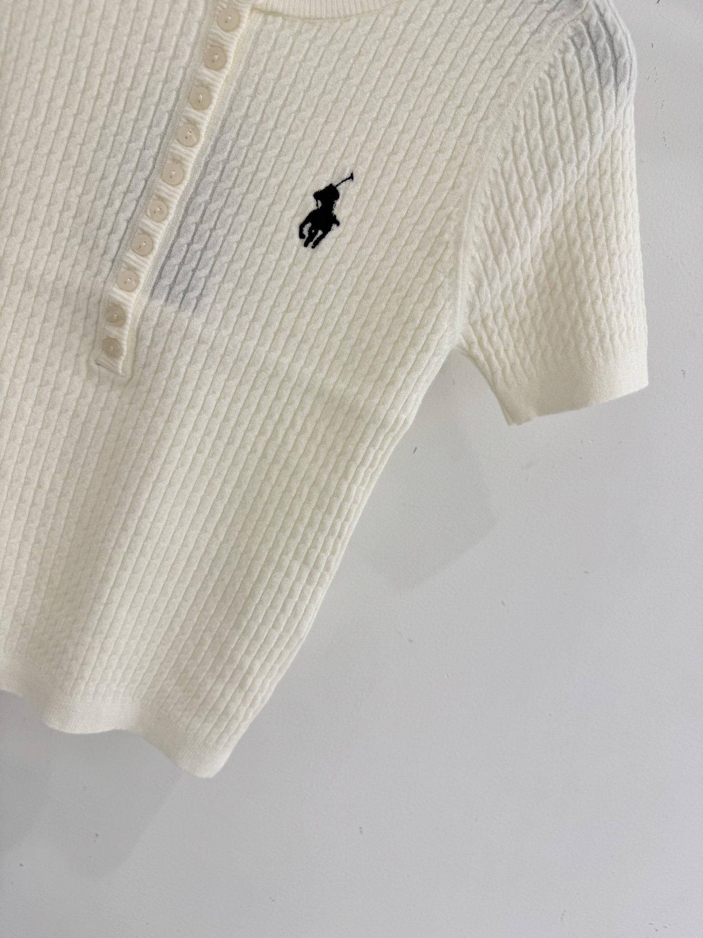 Ralph Lauren ‌圆领半开胸设计，领左胸处绣有品牌 ‌黑色小马标‌，麻花条针织纹理，质地柔软亲肤