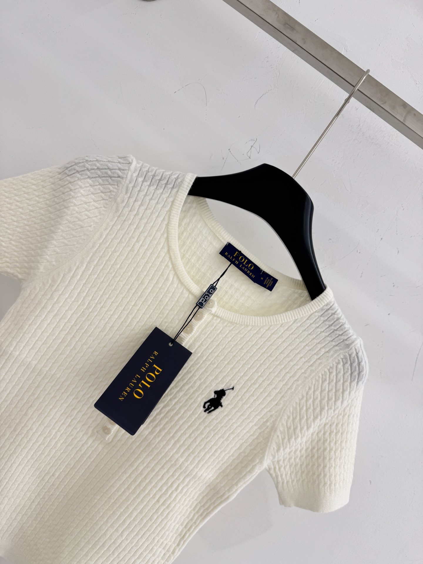 Ralph Lauren ‌圆领半开胸设计，领左胸处绣有品牌 ‌黑色小马标‌，麻花条针织纹理，质地柔软亲肤