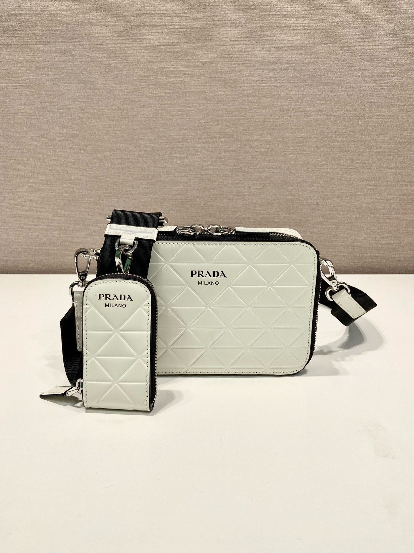 P Family Quilted Camera Bag 2VH070 features imported first-layer glossy embossed cowhide, silk-screened logo, premium hardware, and a detachable adjustable fabric shoulder strap. Double zipper closure, interior slip pocket, and includes a detachable coin pouch. Dimensions: 19 x 12.5 x 5.5 cm. 007880 image 1