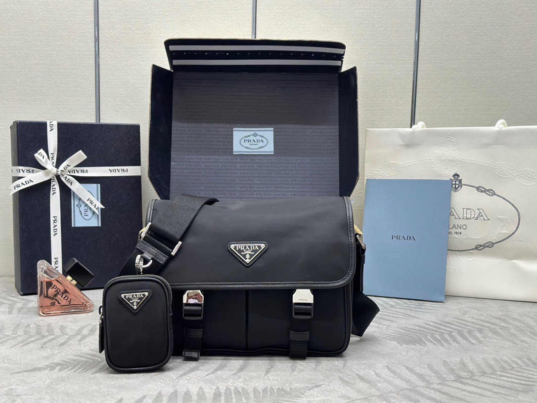 P family  Small Messenger Bag 2VD769. This classic messenger bag is made of imported waterproof fabric, top-grade hardware, and cowhide trim. It features two front pockets, one with a zipper, a back zipper pocket, adjustable long shoulder strap, detachable small bag, and multiple practical compartments. Size: 26 x 20 x 10 cm. image 1