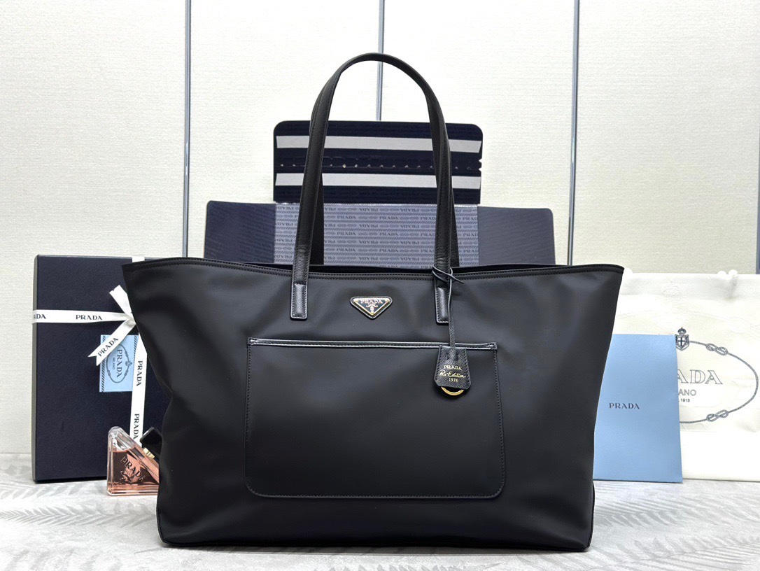 P family  New Large Tote Bag 1BG527. This shopping bag features imported waterproof fabric, leather handles, logo lining, and top-quality hardware. It has an external slip pocket, an internal zip compartment, a detachable 1978 keychain tag, spacious capacity, and is lightweight. Dimensions: 43 x 31 x 15 cm. image 1