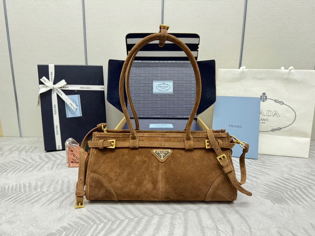 P Brand Small Suede Tote Bag 1BA426  
This Luxsoft tote bag features imported suede, logo lining, and premium hardware. It includes a detachable adjustable long shoulder strap, zipper closure, and an interior zippered compartment. Spacious and ultra-lightweight.  
Size: 32 x 15.5 x 12 cm  
007980 image 1