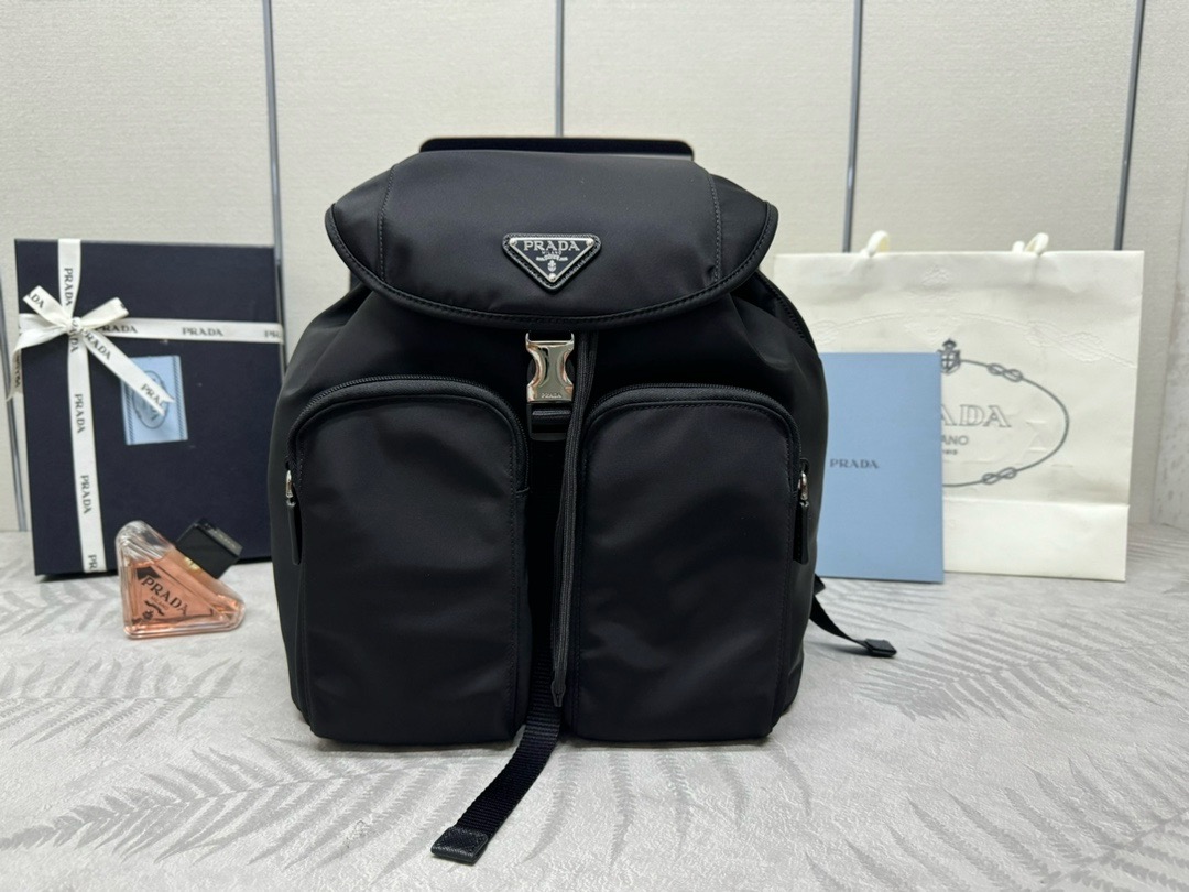P family  Used Backpack 1BZ005 This used backpack features imported parachute waterproof fabric, top-grade hardware accessories, two front zipper pockets, flap buckle design, one interior zipper pocket/patch pocket, spacious capacity, and lightweight. Size: 30 x 34 x 13 007650 image 1