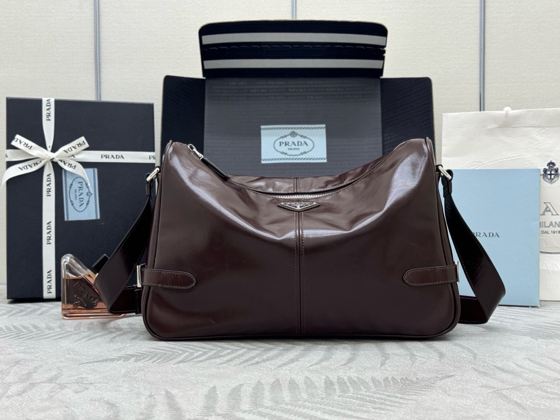 P Brand New Messenger Bag 2VH187. This shoulder bag features imported oil-waxed cowhide, premium hardware, and an adjustable oil-waxed leather strap. Logo lining, zip closure, one zippered interior compartment. Spacious yet lightweight. Size: 35 x 22 x 12 cm. 0071050 image 1