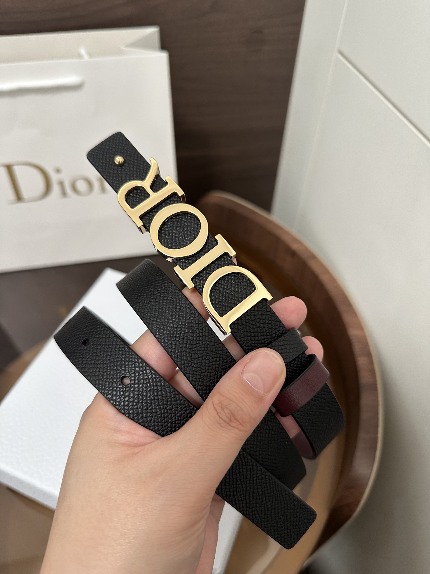 ❣️DI0R 🆕D-Dream 双面腰带
这款 D-Dream 腰带双面设计，搭配可拆卸腰带扣。采用牛皮革等材质精心制作，一面为黑色，另一面为酒红色，搭配富有光泽的金色饰面金属 Dior 腰带扣。搭配两个可拆卸的腰带环，可选择与同色调或对比鲜明的时尚风格搭配。突显腰部曲线，彰显优雅气质，可与牛仔裤、半身裙或连衣裙轻松搭配，打造配套造型。P160