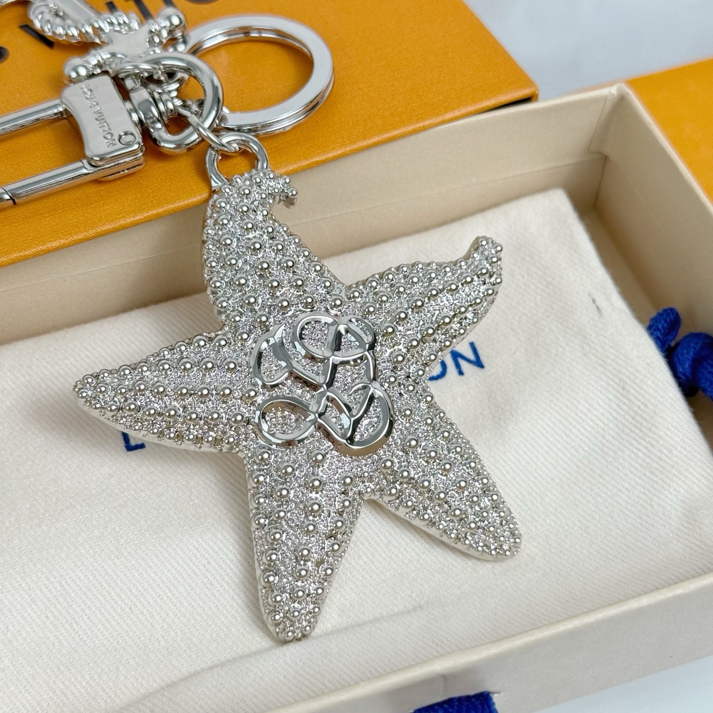 ❤️110包邮/原单代购级别
LV 钥匙扣 海星造型 
LV Starfish 包饰与钥匙扣以华美设计演绎栩栩如生的海星肌理，并将 LV Dynasty 标识点缀其上。缠绕着金属绳索的船锚装饰悬挂于钥匙圈，巧妙呼应 2025 早秋系列的航海主题。
