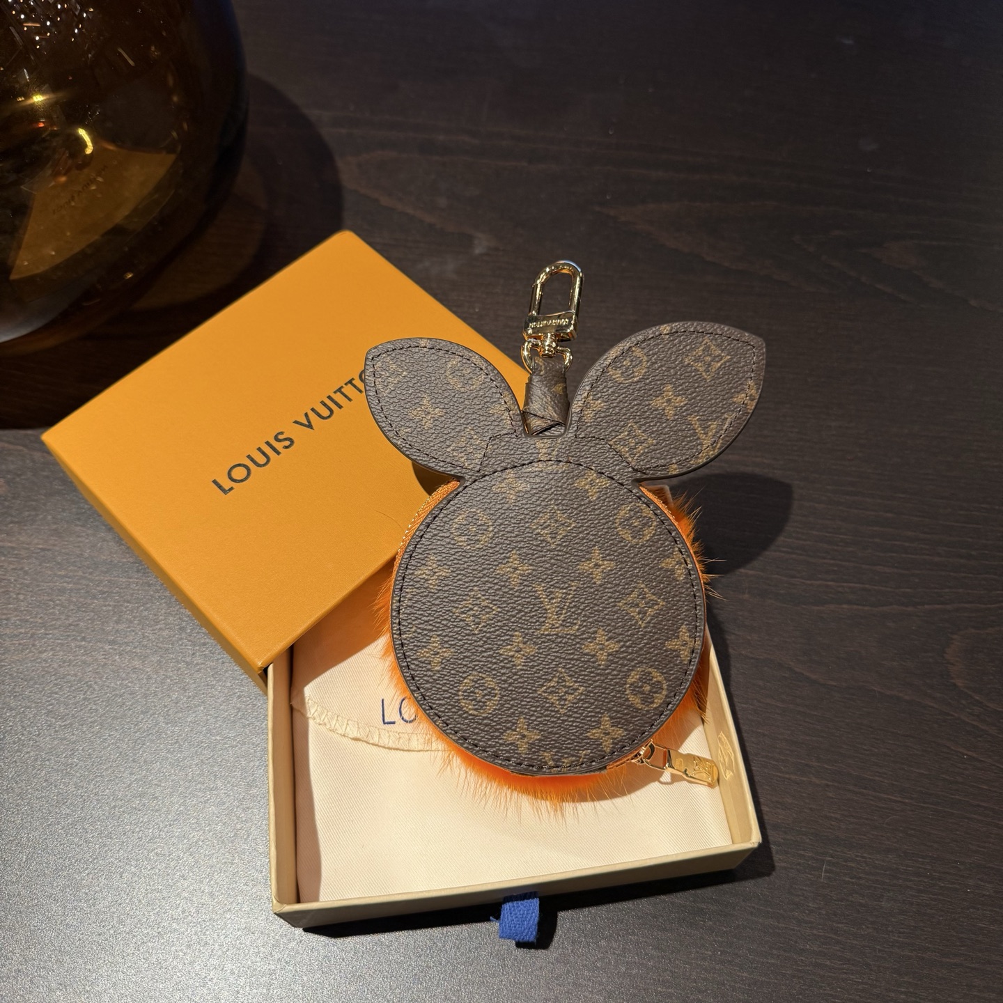 LV柑橘零钱包包挂件包配饰钥匙扣\n材质采用进口整张水貂毛冬季暖绒绒挂件\nLVClementine收纳袋结合细腻皮革和柔软水貂毛皮，裁就明快灵动的柑橘造型，呈现视觉与触觉的双重美学。精巧拉链开启收纳空间，可妥善存放耳机与其他随身小物。