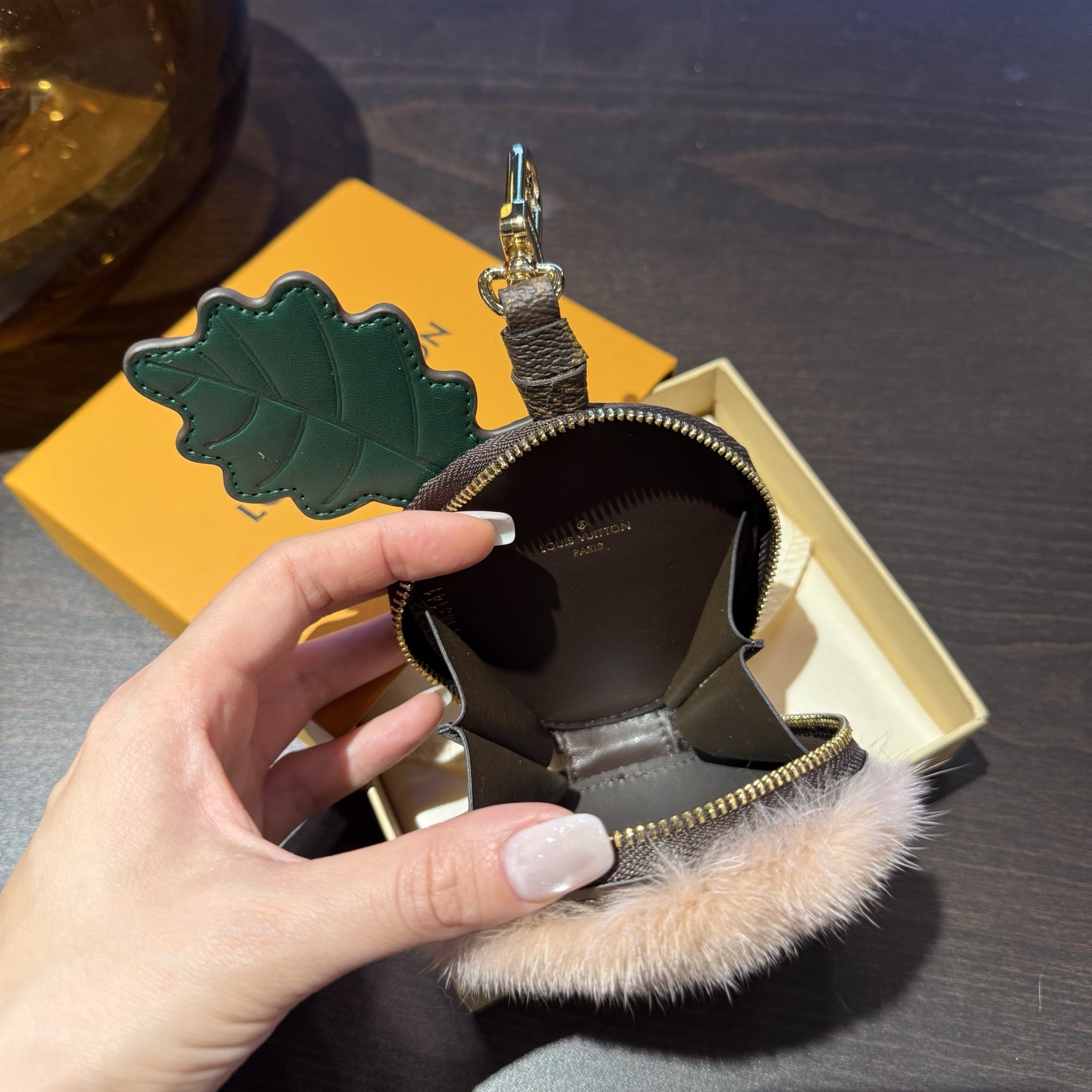 LV栗子零钱包包挂件包配饰钥匙扣\n材质采用进口整张水貂毛冬季暖绒绒挂件\nLVAcorn收纳袋演绎功能与萌趣的不期而遇。Monogram皮革描绘饱满橡果造型，缤纷叶片与柔软水貂毛皮顶部成就细腻质感。可用作拉链小袋，轻松收纳耳机和随身小物。