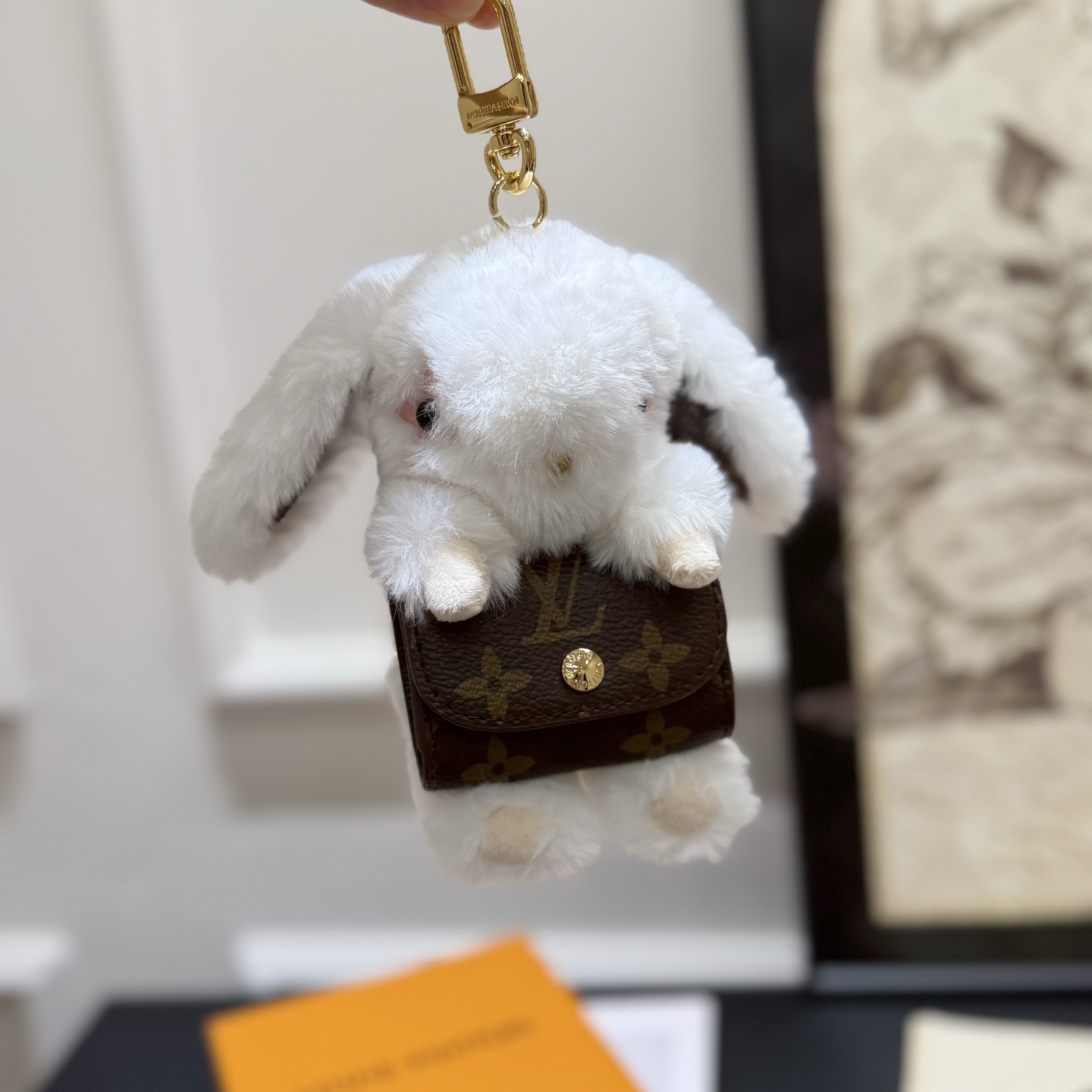 ️LV Cute Buny 包饰以人造毛皮塑造灵动的萌兔形象,其手提的Monogram 帆布袋方便收纳耳机,展现考究设计与功能细节的巧妙融合 7