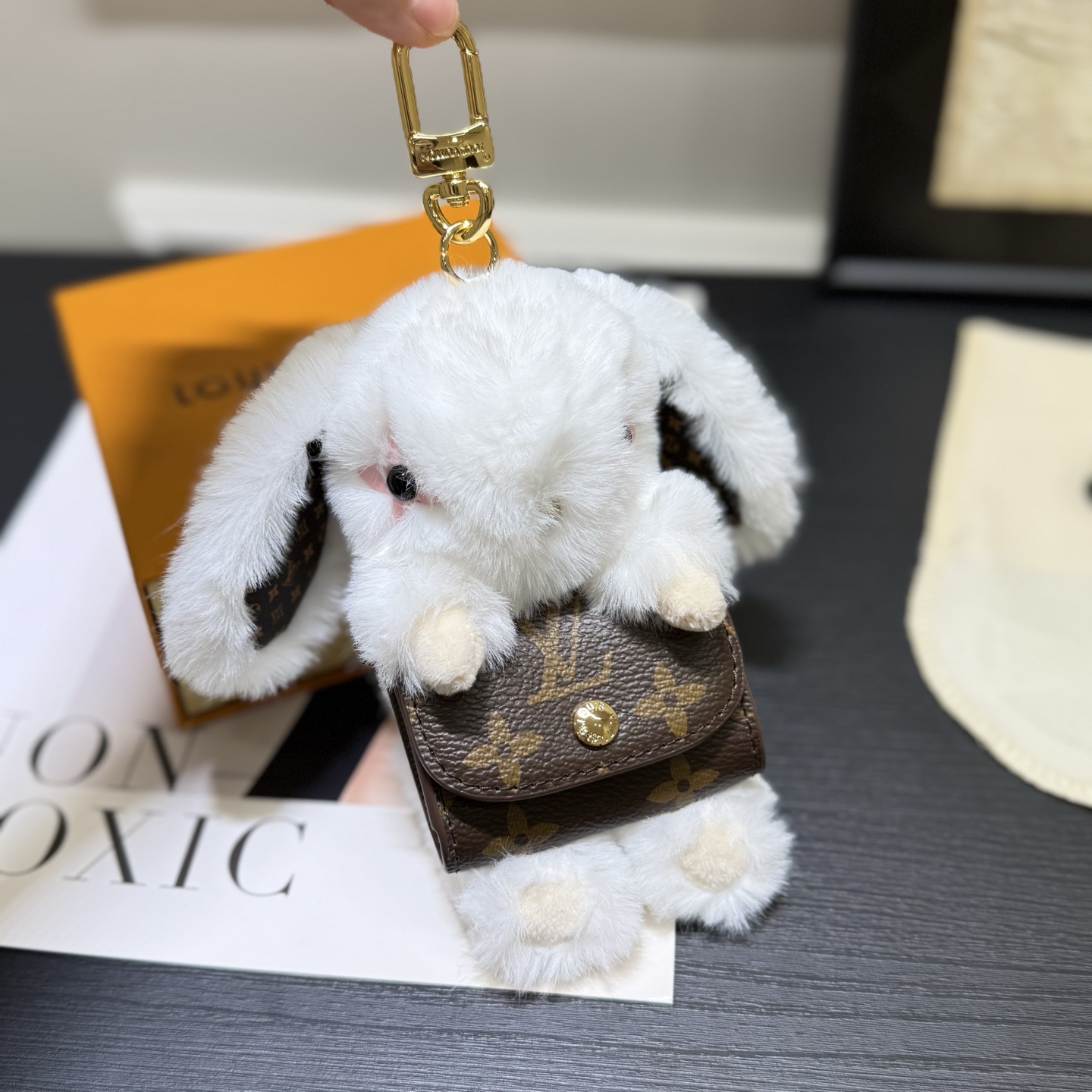 ️LV Cute Buny 包饰以人造毛皮塑造灵动的萌兔形象,其手提的Monogram 帆布袋方便收纳耳机,展现考究设计与功能细节的巧妙融合 5