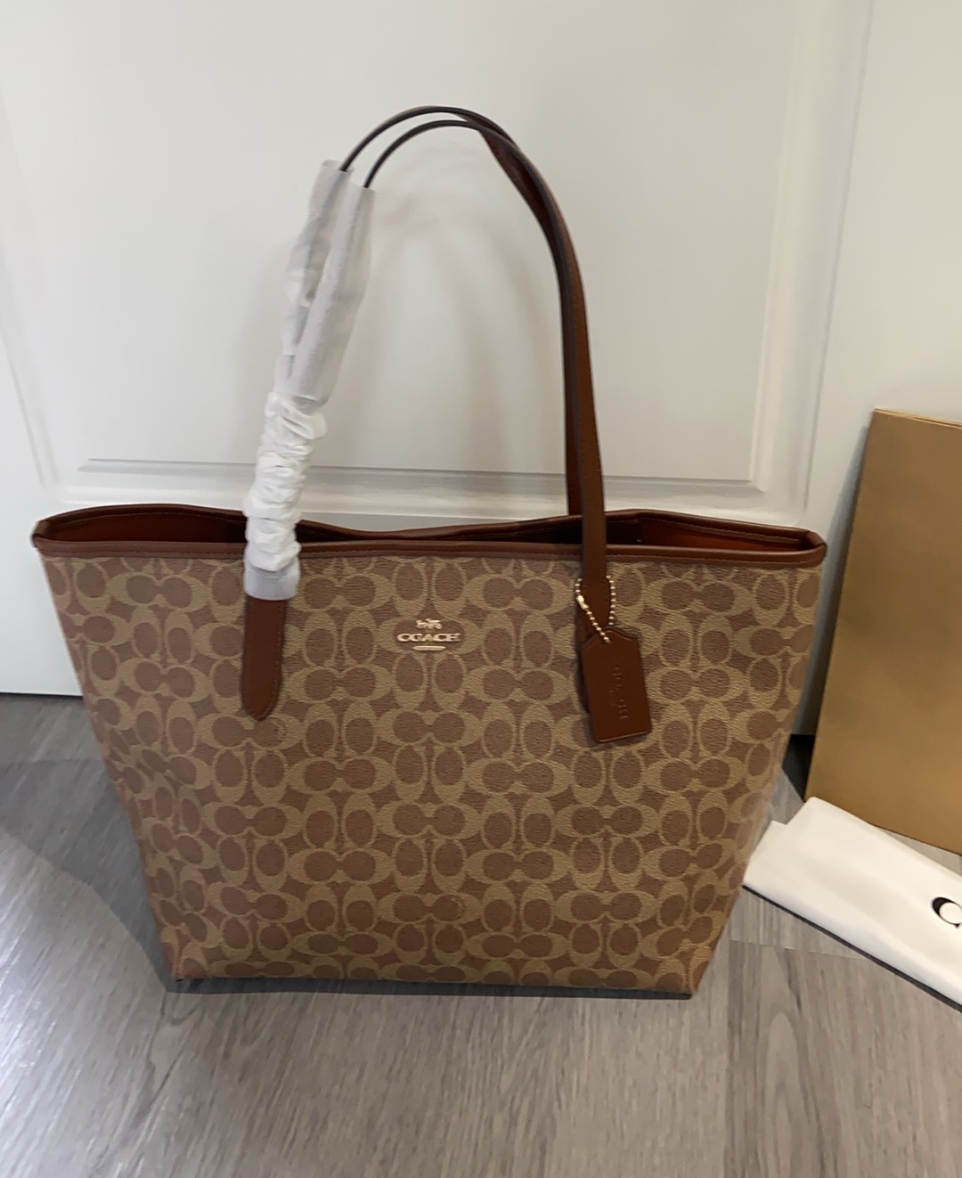 Coach's new model CV976 5696 tote bag in a new color. Made of PVC with leather trim and classic logo-coated canvas. Features a built-in zip pocket, drawstring closure, and vertical handle with a length of 24cm. Dimensions: 33cm (L) x 29cm (H) x 16cm (W). image 1