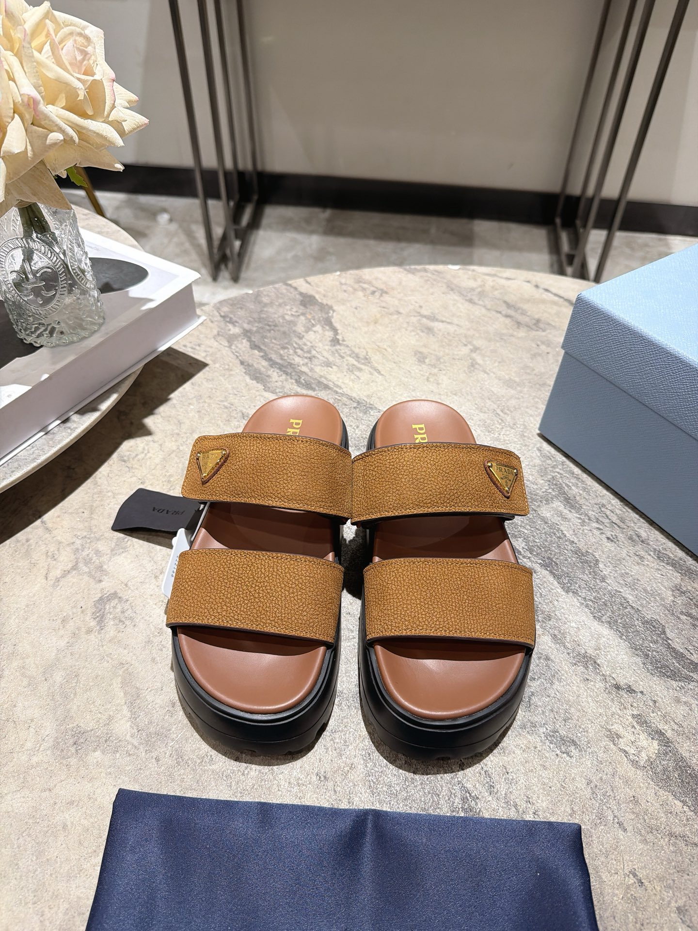 NO:921712,, Prada 26ss new retro thick-soled double-strap sandals for early spring. You can rely on this pair of double-strap sandals to feel relaxed when you go out in the summer. It reshapes the aesthetics of summer dressing with a minimalist double-strap design, which is not deliberate but has a sense of high-end. It is an indispensable and versatile item in the shoe cabinet. The classic thick-soled version is the finishing touch, quietly optimizing the leg line, easily wearing it to show your height, while weakening the dragging feeling of the flat bottom, making the foot stable and light.  The double-strap design fits the foot shape without slipping, making it easy to put on and take off. Whether it is paired with casual shorts, loose jeans, a dress, or a long vacation skirt, it can be seamlessly adapted to easily create a casual and effortless summer look. Imported cow frosted upper, sheepskin lining, original molded outsole, size 35-39 (customized sizes 40 and 41 are non-refundable)  Heel height 5cm, slippers, prada, prada, slippers, skirts, shorts, jeans, sheepskin19860909, Prada普拉达26ss早春新款复古厚底双带凉拖 夏日出街的松弛感,全靠这双双带凉拖拿捏.它以极简的双带设计重塑夏日穿搭美学,不刻意却自带高级感,是鞋柜里不可或缺的百搭单品.经典厚底版型是点睛之笔,悄悄优化腿部线条,轻松穿出显高效果,同时弱化平底的拖沓感,上脚稳当又轻盈. 双带设计贴合脚型不滑落,穿脱便捷度拉满,不管是搭配休闲短裤、宽松牛仔裤,还是连衣裙、度假长裙,都能无缝适配,轻松打造随性不费力的夏日造型. 鞋面进口牛磨砂 内里羊皮 大底原版开模大底 size35-39码（40、41码定制不退换） 跟高5cm,拖鞋,prada,prada,slippers,skirts,shorts,jeans,sheepskin,Women's Shoes