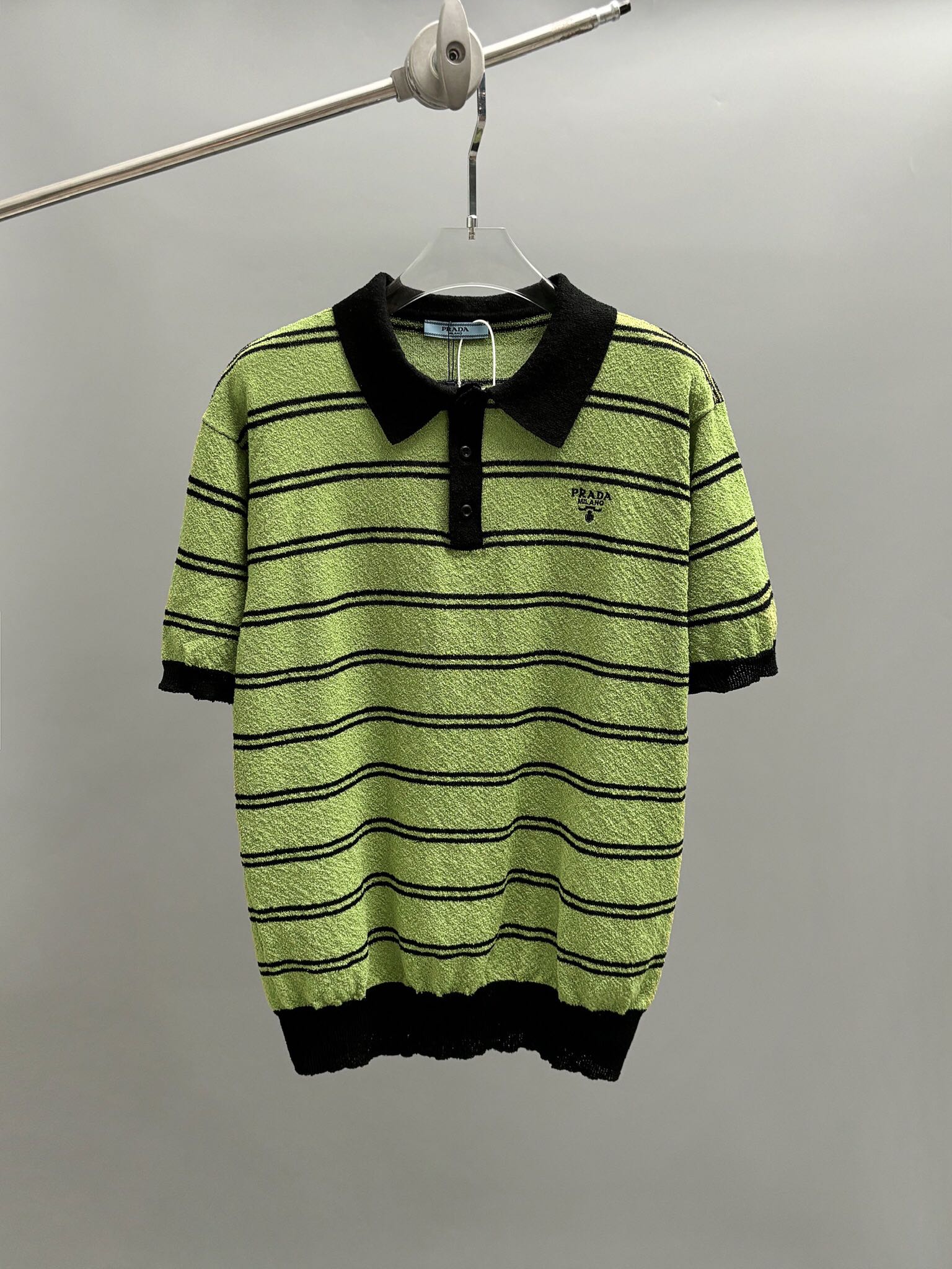 El polo Prada está adornado con el icónico logo esmaltado e integrado con coloridos elementos de moda. Es informal pero…