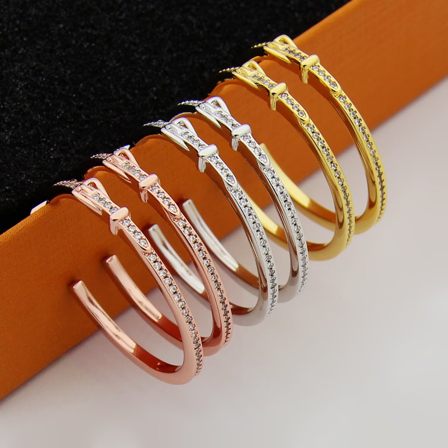 Hermes Buckle Hoop earrings Available in rose gold silver yellow gold metal tones with clear diamond-like accent stones 30mm diameter