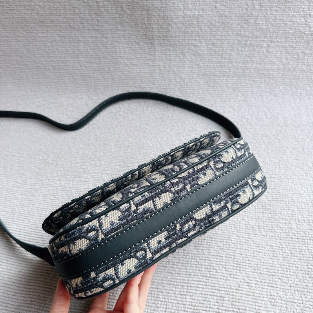 The Dior CD Besace Small Saddle Bag is crafted from Dior blue Oblique print fabric and features a striking metal CD logo with vintage gold finish