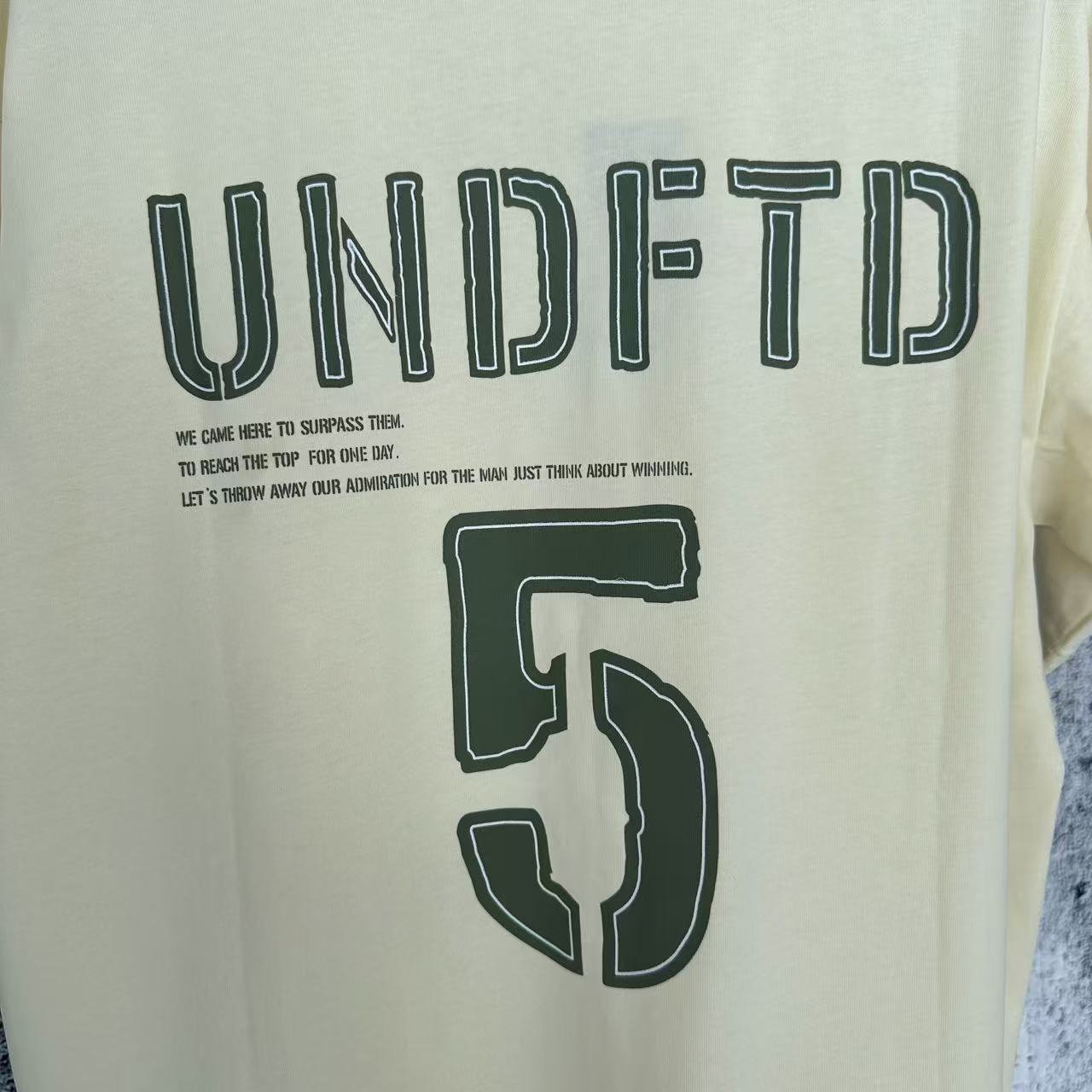 #1082 💰85 挂拍
UNDEFEATED SS25 五条杠Logo字母数字美式复古短袖T恤 男女同款
面料：240g双纱面料，不变型不起球
辅料；全套辅料定制；1:1版本
颜色：黑色，米白色
尺码：S-XL
             S        M         L         XL
胸围   110      114     118      122
衣长    68        70        72       74
肩宽    52        53.5     55      56.5