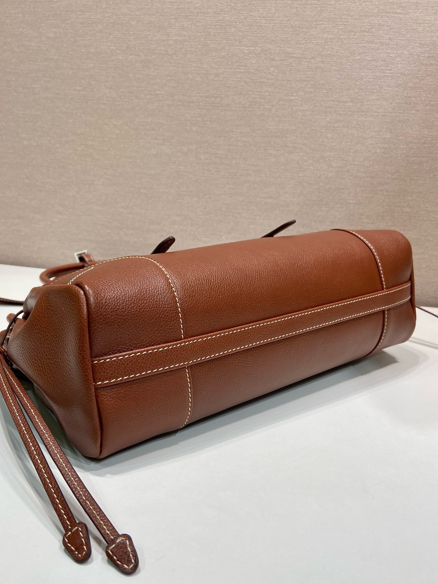 P820新款Bonnie1BG628
这款复古质感的皮包体现了精致而现代的个性。几何轮廓将现代、金属带扣和侧边鞋带设计。而长手柄则表明了一种务实和休闲的态度。配有一条可拆卸长肩带，方便不同场合搭配，容量空间非常大。
尺寸：32 x 17.5 x 10.5