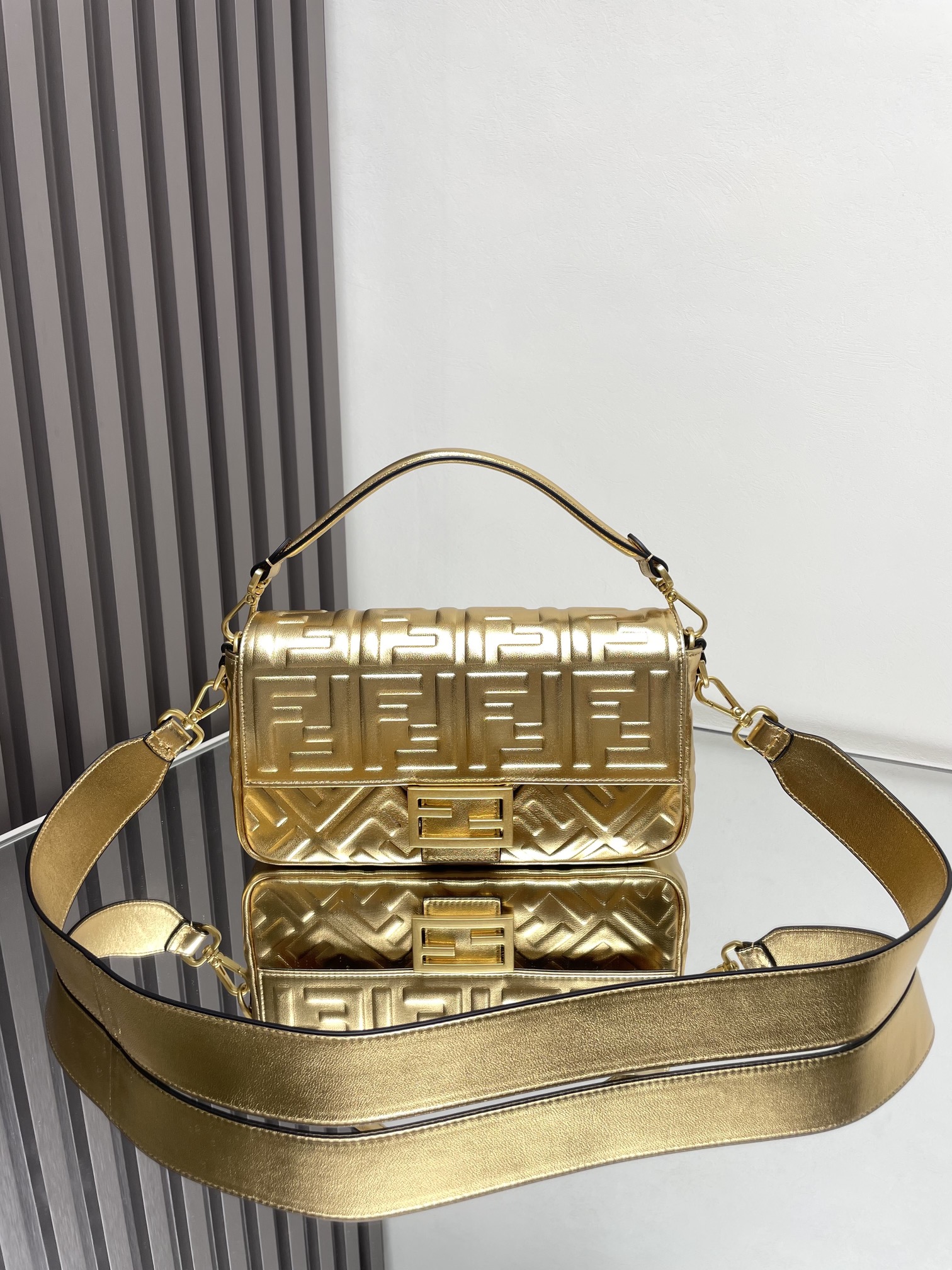 NO:772934,The iconic Baguette medium handbag has a flap design and is equipped with an FF magnetic clasp. The lining is equipped with a zipper pocket. Equipped with a detachable shoulder strap, which can be carried by hand or cross-body. Made of mirror-effect silver leather. Decorated with FF embossed pattern. Palladium-plated metal finish. Size 26cm 211, Fendi FENDI, fendi, fendi19860909标志性的Baguette中号手袋采用翻盖设计,配有FF磁扣.内衬配有拉链袋.配备可拆卸肩带,可手提或斜挎.镜面效果银色皮革材质.饰有FF压花图案.镀钯金属饰面.尺寸26cm 211,芬迪FENDI,fendi,fendi,Bag