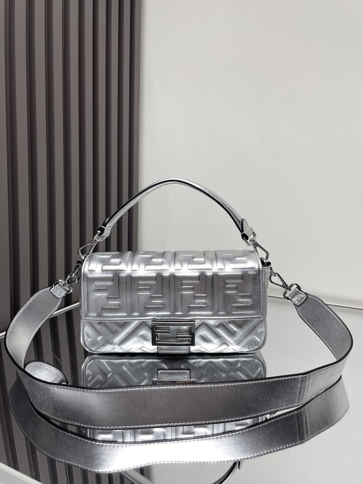 NO:772929,The iconic Baguette small handbag has a flap design and is equipped with an FF magnetic clasp. The lining is equipped with a zipper pocket. Equipped with a detachable shoulder strap, which can be carried by hand or cross-body. Made of mirror-effect silver leather. Decorated with FF embossed pattern. Palladium-plated metal finish. Size 26cm 211, Fendi FENDI, fendi, fendi19860909标志性的Baguette小号手袋采用翻盖设计,配有FF磁扣.内衬配有拉链袋.配备可拆卸肩带,可手提或斜挎.镜面效果银色皮革材质.饰有FF压花图案.镀钯金属饰面.尺寸26cm 211,芬迪FENDI,fendi,fendi,Bag