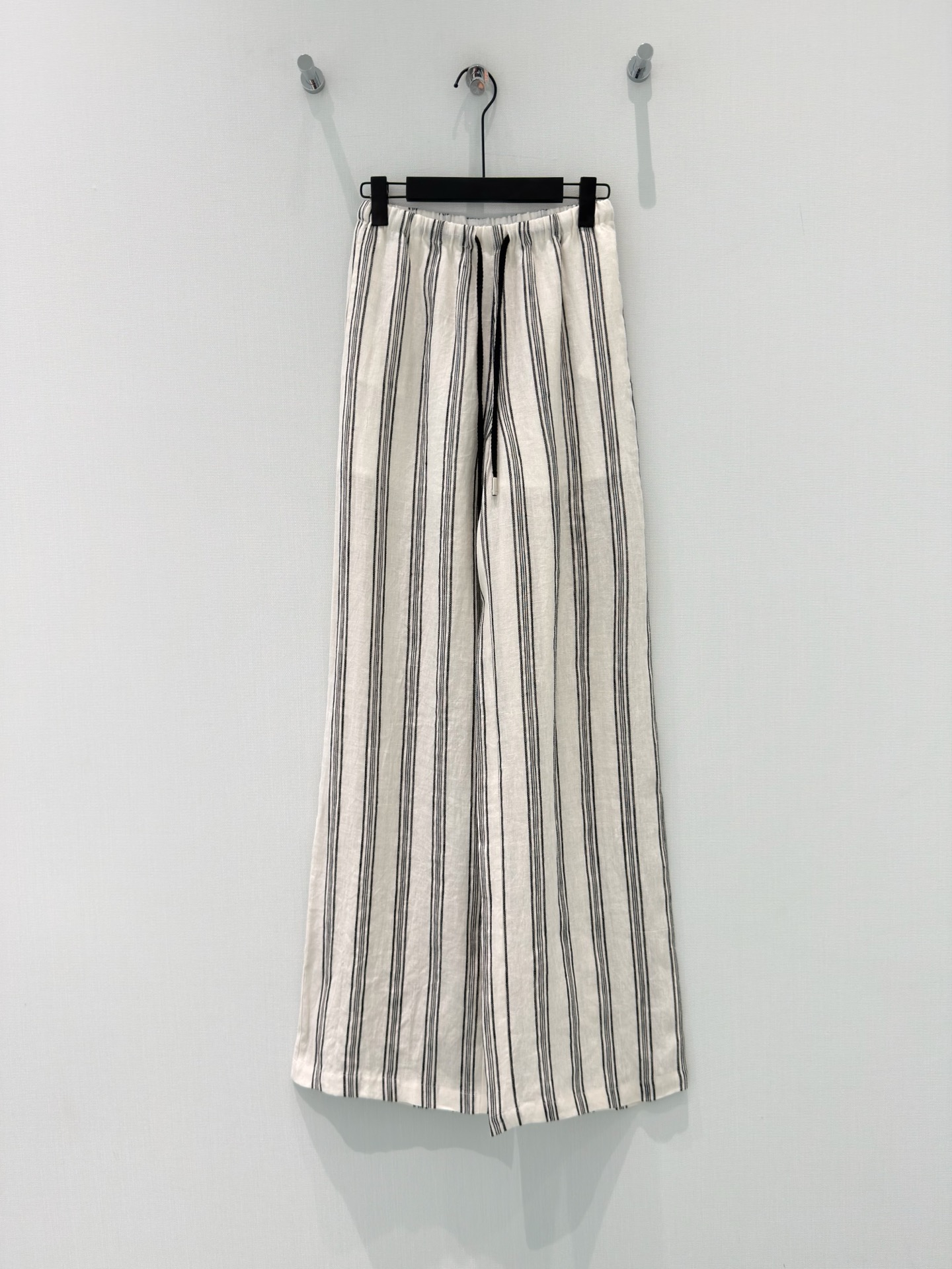 NO:833615,[26 Summer New Design Fragrance Style Back Pocket Embroidered Linen Striped Wide Leg Pants]  These linen striped wide-leg pants bring the freshness and relaxation of summer to the body. The natural linen fabric has a breathable texture, like a walking air conditioner. It is breathable and wicks away sweat without stuffiness, saying goodbye to the sticky feeling in summer. The classic black and white vertical stripes are neat and slimming, visually elongating the leg lines; the elastic waist is matched  The simple drawstring makes it easy and comfortable to put on and take off, and the exquisite embroidered details on the back waist are low-key and high-end. The drapey wide-leg version accommodates various leg shapes, making it lazy and casual without losing style. Whether it is daily commuting or leisure outings, it can be easily worn with T-shirts and shirts to create a relaxed and fashionable atmosphere.  S-L,,shirts,tees,t-shirt,19860909【26夏季新款设计香风后口袋刺绣亚麻条纹阔腿裤】 这款亚麻条纹阔腿裤,是把夏日的清爽与松弛穿在了身上.天然亚麻面料自带透气肌理,仿佛行走的空调,透气排汗不闷汗,告别夏日黏腻感.经典黑白竖条纹利落又显瘦,视觉上悄悄拉长腿部线条；松紧腰搭配简约抽绳,穿脱方便又自在,后腰的精致刺绣小细节,低调又透着高级感.垂坠的阔腿版型包容各种腿型,慵懒随性又不失格调,不管是日常通勤还是休闲出游,搭配T恤、衬衫都能轻松穿出松弛又时髦的氛围感. S-L,,shirts,tees，t-shirt,,Women's clothing