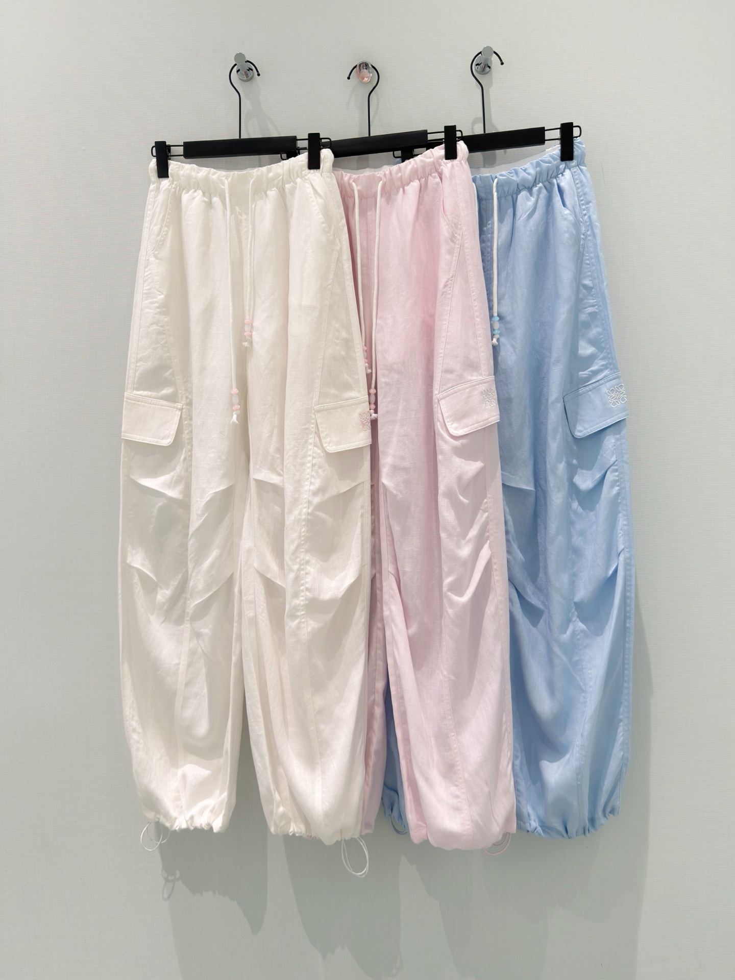 NO:841426,[26 new summer style elastic waist + beaded drawstring design embroidered Tencel linen workwear leggings | Breathable, cool, lazy, relaxed, slimming and versatile] The 'cooling pants' you just need in summer are here!  Made of 60% Tencel linen golden ratio fabric, it has a cooling buff, feels clear and soft, the upper body is breathable and does not make you sweaty, and it does not feel stuffy when worn in summer. It has a loose workwear style, with side pockets with exquisite embroidery details, and the pants have natural pleats, which can easily hide the flesh and make you look slimmer. It is very friendly to sisters with wide hips and thick legs.  The elastic waist + beaded drawstring design is not tight at the waist, and the adjustable trouser leg design can be worn with the feet tied to create a neat work style, or can be worn straight to create a relaxed and lazy feeling. It is very practical to wear two pants. The three colors of white/pink/blue are gentle and refreshing macaron colors, suitable for T-shirts, suspenders, and sun protection shirts. They can be worn for daily commuting, traveling, and shopping, and will provide you with a refreshing look throughout the summer~  S-L,,tees,t-shirt,gold,19860909【26夏季新款夏日松紧腰+串珠抽绳设计刺绣天丝亚麻工装束脚裤｜透气凉感 慵懒松弛 显瘦百搭】 夏日刚需的“降温神裤”来啦！ 采用60天丝亚麻的黄金配比面料,自带凉感buff,摸起来清透软糯,上身透气不闷汗,夏天穿也毫无闷热感. 宽松工装版型,侧边口袋搭配精致刺绣细节,裤身自带自然褶皱,轻松藏肉显瘦,对胯宽、腿粗的姐妹超友好. 松紧腰+串珠抽绳设计,不勒腰不紧绷,可调节裤脚设计,既能束脚穿打造利落工装风,也能直筒穿穿出松弛慵懒感,一裤两穿超实用. 白/粉/蓝三色都是温柔清爽的马卡龙色系,适配T恤、吊带、防晒衫,日常通勤、出游、逛街都能穿,承包你整个夏天的清爽造型~ S-L,,tees，t-shirt,gold,,Women's clothing