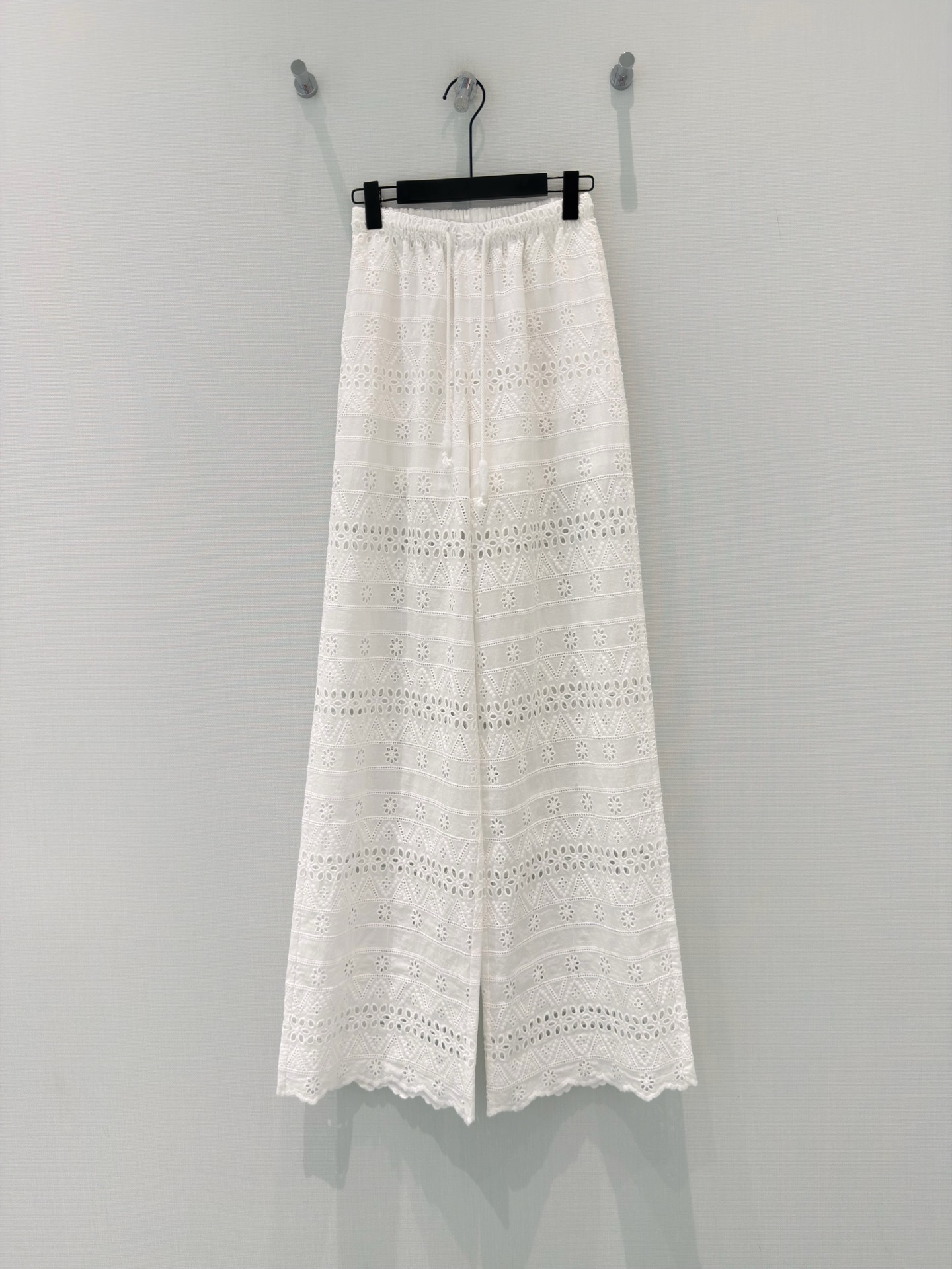 NO:861537,Designer [26 new summer vacation style cotton heavy-duty hollow embroidered wide-leg pants] Pure cotton fabric, with a natural breathing feeling, soft touch like wrapped clouds, refreshing and breathable in summer. Full heavy-duty hollow embroidery, geometric and flower patterns spread layer by layer, with a vague and hazy atmosphere when walking; The jade-like beaded drawstring at the waist can hide the belly with a single tie, making it lazy and delicate.  The slightly wide trousers shape your legs, and they are paired with wavy lace trousers to give you a relaxed vacation feel. You can wear them with T-shirts and suspenders to create a refreshing and gentle summer atmosphere. They are the white moonlight pants that bring fairyland to your wardrobe. SML,,tees,t-shirt,19860909设计师【26夏季新款夏日度假风设计棉重工镂空刺绣阔腿裤】 纯棉面料,带着自然呼吸感,软乎乎的触感像裹着云朵,夏天穿清爽又透气. 满幅重工镂空刺绣,几何与花朵纹样层层铺展,走动时带着若隐若现的朦胧氛围感；腰头的玉石感串珠抽绳,轻轻一系就藏住小肚子,慵懒又精致. 微阔的裤型修饰腿型,搭配波浪花边裤脚,自带松弛度假感,搭T恤、吊带都能穿出清爽温柔的夏日气息,是衣柜里自带仙气的白月光神裤. SML,,tees，t-shirt,,Women's clothing