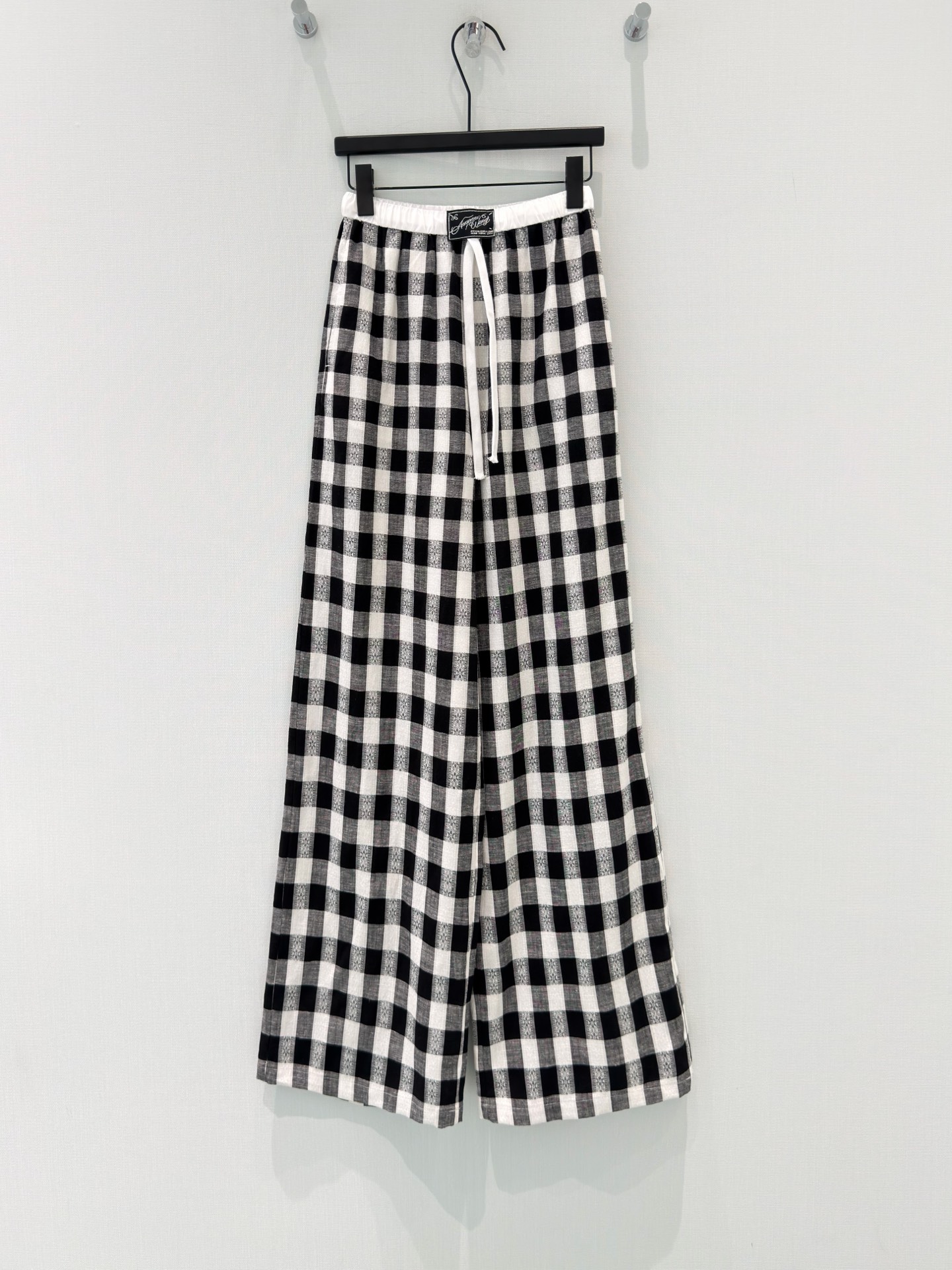 NO:870836,[26 new summer Korean style relaxed and lazy design label black and white plaid elastic high-waisted color-blocked lyocell linen wide-leg pants] The black and white plaid with its own refreshing filter is synonymous with relaxation in summer. It is lazy and attractive to wear casually.  Selected 75 lyocell + 25 linen blended fabric, it is cool, breathable and not sweaty. It has a great drape feeling and can be carried by the wind while walking and can also hide the flesh. The elastic waistband is matched with a drawstring design, which can be worn without any restriction regardless of the waist shape. The wide straight-leg pants 'hide the flesh' from the crotch to the calf, and the pear-shaped figure can also easily look like a paper man.  Pair it with a T-shirt for a casual style, with suspenders for a Korean-style relaxed feel, and the black and white classic plaid pattern can easily match your wardrobe throughout the summer without choosing the color of the top. SML,, tees, t-shirt,19860909【26夏季新款韩系松弛感慵懒设计贴标黑白格纹松紧高腰拼色莱赛尔亚麻阔腿裤】 自带清爽滤镜的黑白格纹,是夏日里的松弛感代名词,随便穿都慵懒又耐看. 精选75莱赛尔+25亚麻混纺面料,自带凉感透气不闷汗,垂坠感绝了,走路带风还能藏住肉肉.松紧腰头搭配抽绳设计,不挑腰型穿着零束缚,宽直筒裤型从胯部到小腿一路“藏肉”,梨形身材也能轻松穿出纸片人效果. 搭配T恤是休闲随性风,配吊带就是韩系松弛感,黑白经典格纹不挑上衣颜色,轻松承包你整个夏天的衣柜搭配. SML,,tees，t-shirt,,Women's clothing
