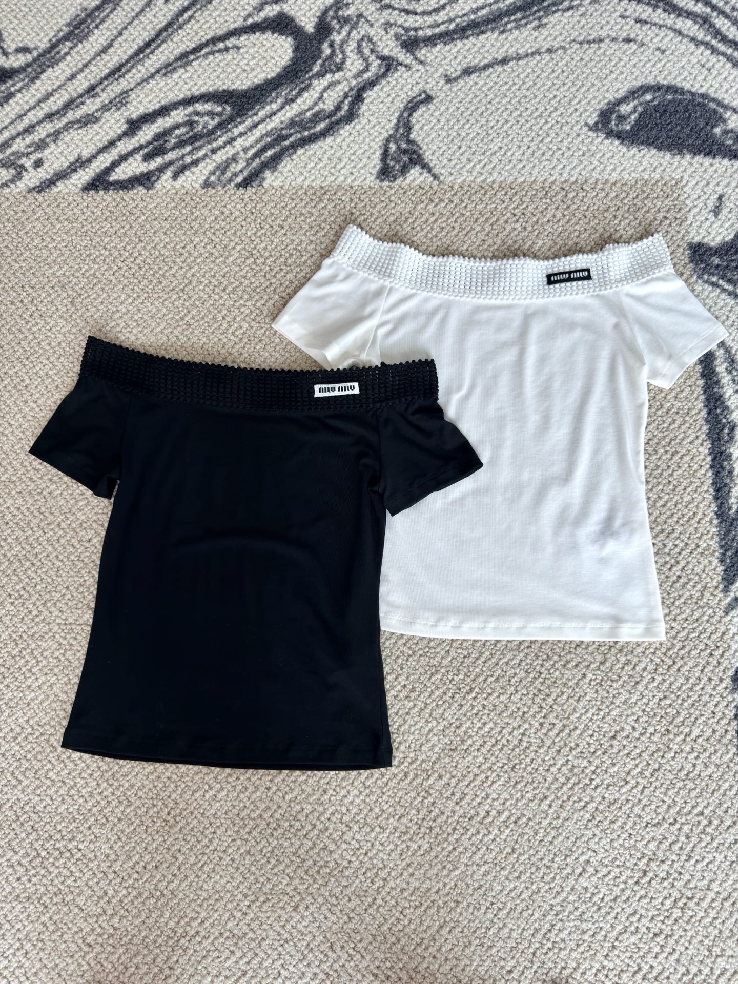 NO:878129,[26 new summer style pure lust style design Tencel acetate one-shoulder letter short-sleeved T-shirt top] Tencel acetate one-shoulder short-sleeve | Unlock the lazy pure desire atmosphere  Selected 68 Tencel + 25 acetate blended fabric, which feels as soft and smooth as clouds, has a coolness, is breathable and does not make you sweat. The wide-edge hollow textured one-line collar delicately exposes the collarbone line. The short cut optimizes the body proportions and is slim but not tight. The small logo details are embellished with light and luxurious texture. The black and white two-color are versatile and can be worn alone or with a skirt. It is suitable for daily commuting and dating.  French off-shoulder Tencel acetate T-shirt, a high-end feel. The acetic acid blessing gives the fabric a delicate drape, which is not easy to deform and wrinkle after long-term wear. The three-dimensional hollow elastic one-line shoulder has moderate elasticity without strangling the neck, and just shows the curve of the shoulder and neck. The simple short sleeves neatly hide the flesh, and the classic black and white colors are both slim and versatile. The comfortable fabric is close to the skin, making it refreshing and comfortable to wear in the hot summer, creating a casual and exquisite outfit.  Pure lust-style one-shoulder short top | Tencel acetic acid ice-like fabric. Ice-moist Tencel acetic acid fabric comes with a cooling buff, is soft and skin-friendly without restraint. The elasticated one-line collar with bubble texture is anti-slip and not easy to slip off. It gently exposes the collarbone and highlights the superior line of the neck. The short and slim fit raises the waistline, optimizing the head-to-body ratio. The black/white basic color can easily match wide-leg pants and short skirts, making it easy to create a Korean hot girl outfit every day.  S-L,,skirts,T-shirt,tees,t-shirt,19860909【26夏季新款纯欲风设计天丝醋酸一字肩字母短袖T恤上衣】 天丝醋酸一字肩短袖｜解锁慵懒纯欲氛围感 甄选68天丝+25醋酸混纺面料,触感如云般软糯顺滑,自带凉感透气不闷汗.宽边镂空肌理一字领,精巧露出锁骨线条,小短款剪裁优化身材比例,修身不紧绷.小标细节点缀轻奢质感,黑白双色百搭不挑穿搭,单穿配牛仔、搭半身裙都出彩,日常通勤、约会出片都适配. 法式露肩天丝醋酸T恤,高级感随手拿捏 醋酸加持赋予面料细腻垂坠感,久穿不易变形起皱.立体镂空松紧一字肩,弹力适中不勒脖颈,恰到好处展露肩颈曲线.简约小短袖利落藏肉,黑白经典双色,兼顾显瘦与百搭,舒适面料贴身亲肤,酷暑穿着清爽自在,打造随性精致穿搭. 纯欲风一字肩短上衣｜天丝醋酸冰感面料 冰润天丝醋酸面料自带降温buff,软糯亲肤贴肤无束缚.泡泡肌理松紧一字领,防滑不易滑落,温柔露锁骨凸显脖颈优越线条.短款修身版型拉高腰线,优化头身比,黑/白基础色轻松适配阔腿裤、短裙,日常轻松打造韩系辣妹穿搭. S-L,,skirts,T-shirt,tees，t-shirt,,Women's clothing