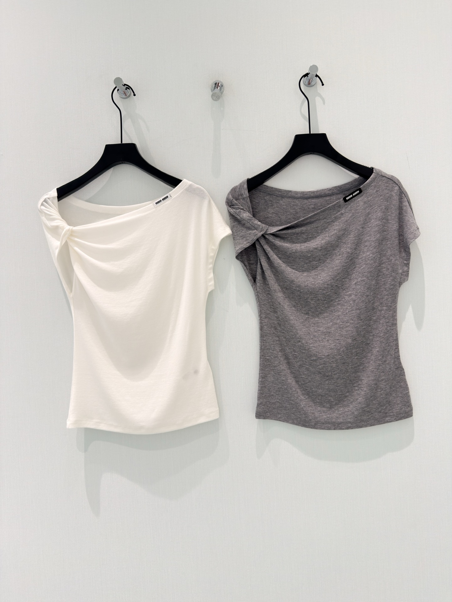 NO:884741,[26 new summer style gentle and sexy design letter Lyocell Tencel wool twisted shoulder short-sleeved T-shirt top] Version 1 gentle temperament style fairy T-shirt that welds laziness and sophistication on the body is here!  The oblique shoulder twist design has a relaxed atmosphere and exposes the collarbone line, which is gentle and a little sexy~ The golden ratio of 76 Lyocell Tencel + 19 wool + 5 spandex, soft and fufu like clouds against the skin, has a cool feeling and is breathable without being sweaty. It is refreshing when worn alone, and super layered when layered.  Slim-fitting but not tight tailoring, quietly modifying the body curve, two fairy colors of white moonlight & high-end gray, you can look good with your eyes closed. It is very suitable for daily commuting and dating, giving you a gentle sister-like look~ Version 2 simple and advanced style Miu style atmospheric slanted shoulder kink T-shirt, with a high-end sense of relaxation. Asymmetrical slanted shoulder collar + unilateral kink design, weakening the shoulder line, optimizing the head-to-shoulder ratio, giving it a lazy and noble feeling.  Lyocell Tencel wool blended fabric is skin-friendly and breathable, with a full drape. It is easy to wear against the skin and is not easy to wrinkle and easy to take care of. The slim fit is not tight and suitable for various body shapes. The classic color combination of black, white and gray (here is white & gray) makes it easy to create a high-end look. It is the versatile king in the wardrobe!  Version 3 short copywriting Who knows?  This slanted shoulder T-shirt is so good!  The one-sided kink design exposes the beautiful collarbone, and the feeling of pure lust directly fills up ~ Lyocell Tencel wool fabric, soft and skin-friendly, refreshing and not stuffy in summer, and gentle in autumn and winter. The two colors of white & gray are super versatile, they look good with jeans and skirts, they look slim and elegant, close your eyes!  S-L,,miumiu,skirts,jeans,T-shirt,tees,t-shirt,gold,19860909【26夏季新款温柔小性感设计字母莱赛尔天丝羊毛扭结斜肩短袖T恤上衣】 版本1温柔气质风 把慵懒和精致焊在身上的神仙T恤来啦！ 斜肩扭结设计自带松弛氛围感,露出锁骨线条,温柔又带点小性感~ 76莱赛尔天丝+19羊毛+5氨纶的黄金配比,软fufu的像云朵贴肤,自带凉感还透气不闷汗,单穿清爽,叠穿也超有层次. 修身但不紧绷的剪裁,悄悄修饰身材曲线,白月光&高级灰两个神仙色,闭眼入都不出错,日常通勤、约会穿都很适配,一整个温柔姐姐既视感~ 版本2简约高级风 Miu系氛围感斜肩扭结T恤,拿捏高级松弛感. 不对称斜肩领+单侧扭结设计,弱化肩线、优化头肩比,自带慵懒贵气感. 莱赛尔天丝羊毛混纺面料,亲肤透气,垂坠感拉满,贴肤穿着无负担,不易皱好打理. 修身不紧身的合身版型,适配各种身形,黑白灰（这里是白&灰）经典配色,轻松搭出高级感,衣柜里的百搭王就是它！ 版本3种草短文案 谁懂啊！这件斜肩T恤也太会了！ 单侧扭结设计,露出好看的锁骨,纯欲感直接拉满~ 莱赛尔天丝羊毛面料,软乎乎巨亲肤,夏天穿清爽不闷,秋冬内搭也温柔. 白&灰两个颜色都超百搭,随便配牛仔裤、半身裙都好看,显瘦又气质,闭眼冲！ S-L,,miumiu,skirts,jeans,T-shirt,tees，t-shirt,gold,,Women's clothing