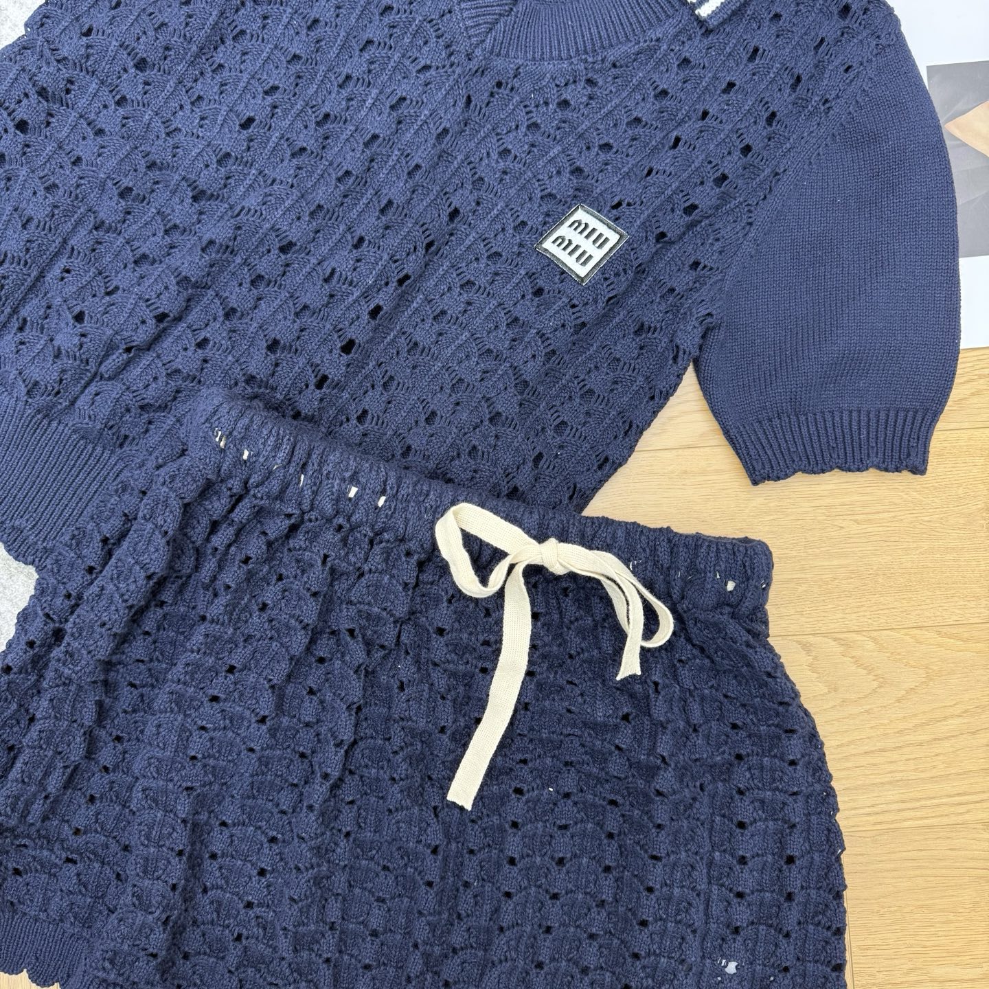 Miu系26春夏翻领针织套装，镂空钩花肌理通透又精致，撞色条纹翻领，同色系短裙搭配蝴蝶结抽绳，甜酷感平衡