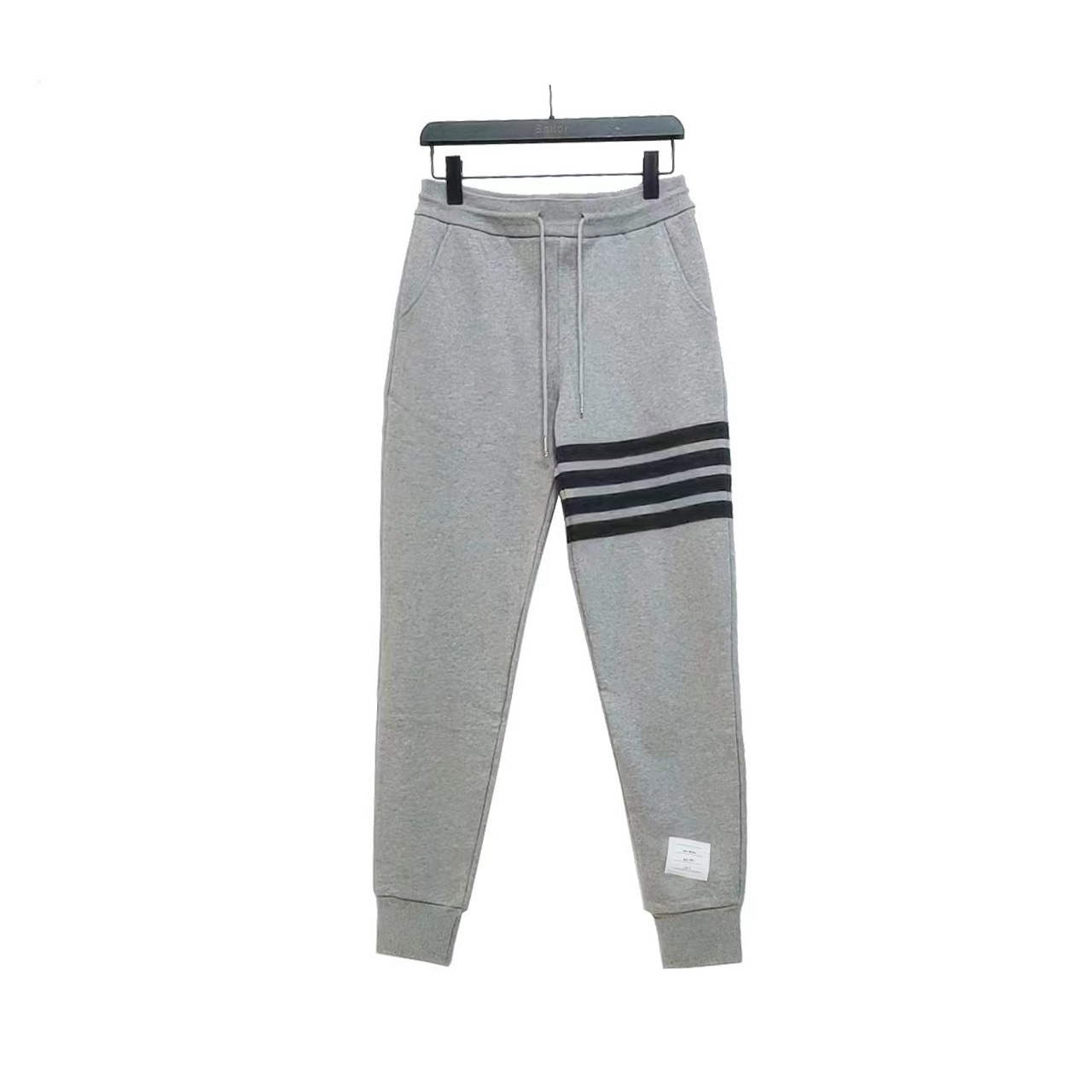 ＃新春福利 THOM BROWNE 汤姆布朗. TB灰条蓝条色织四条杠长裤 所有材料辅料均原版开模 成本1xx 清仓福利 高端私域跑量神器 懂工艺的铁子一眼秒懂！高级感，全藏在看不见的加工细节里，拒绝市场通货偷工减料，每一处都对标品牌原厂工艺： ✅ 四杠对位拼接工艺：侧边标志性四杠并非简单印花，采用高密度纯棉织带手工对位缝合，针距均匀密致，久穿洗水不脱线、不移位，左右四杠精准对称，这是通货做不到的细节； ✅ 口袋&腰部双重包边：内里口袋全做加密包边处理，腰部红白蓝织带包边一体成型，不磨腰、不脱散，运动拉扯也不易变形； ✅ 定制螺纹与全套辅料：裤脚定制高弹罗纹，经过多次拉伸测试仍能回弹紧致，不松垮堆堆；腰头抽绳、金属气眼、侧边皮质标，全套原厂级辅料，质感摸得到； ✅ 立体剪裁工艺：按人体工学做收腿版型，裆部加固缝合，避免运动开裂，兼顾版型利落与穿着舒适度。 TB长裤色织经典色织灰、蓝彩条四条杠长卫裤 ZP面料色织定制 380克重经典毛圈棉 高清还原细节 做工精细 采用进口缝纫设备缝制 针距细密 螺纹裤头定制弹性织成 五金裤绳可转动 男女同款⚠️+专柜包装防尘袋 三标齐 高版本-选品中心