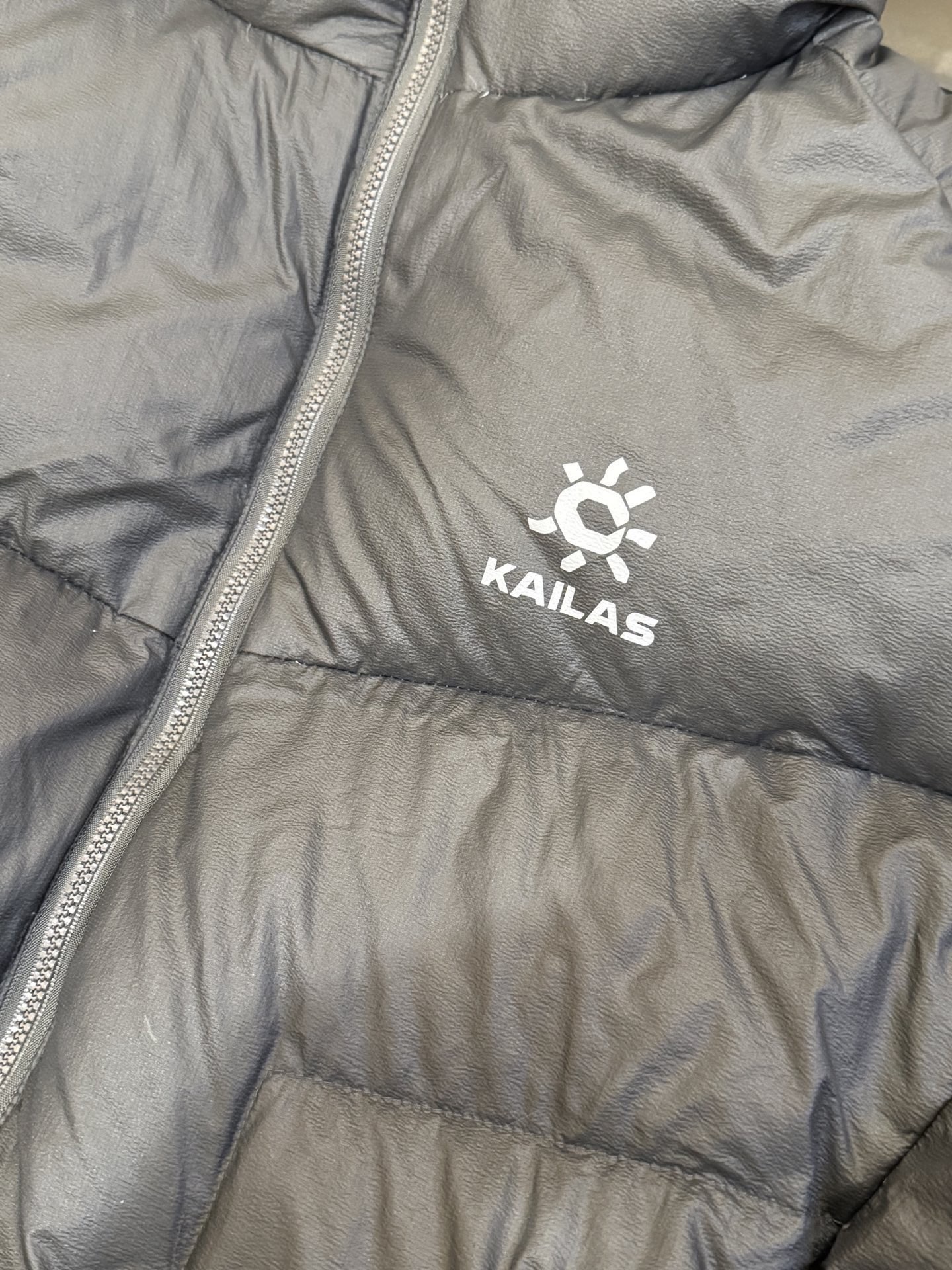 图片[3]-# 新春福利 KAILAS 凯乐石 5000GT 户外运动登山徒步轻量透气拒水1000蓬羽绒服 超级轻薄半透面料，绒朵透光可见，所以这款填充绒必须足够好，否则没法看！ 肉眼可见的超级蓬松，这款因为填充的绒朵好，才能呈现出鼓鼓囊囊的效果，超轻超蓬松 填充国标拒水90白鸭绒，区别于市面假90绒。 面料为涤纶暗格，市面无同款面料，定制定染色后再做防水；为还原原版质感与手感，打样无数次才最终满意。里布工艺同样复杂，生产周期漫长。 所有五金辅料均为定制定染色：整衣采用三种不同拉链头，内里口袋配特殊色拉链，帽子及下摆抽绳、帽子气眼，均攻克极高工艺难度，完美呈现。 颜色：乌木黑 尺码：XS S M L XL XXL-选品中心