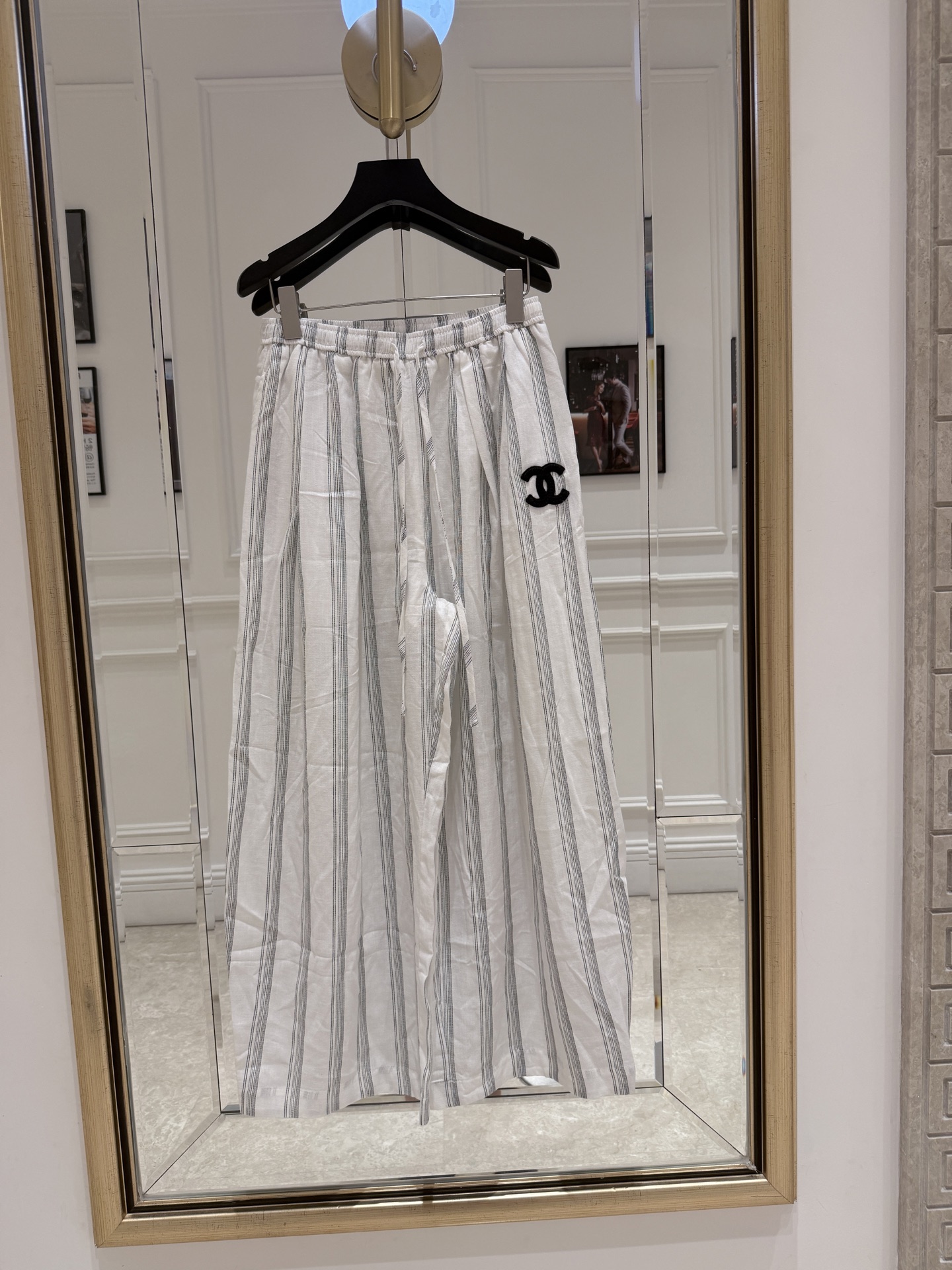 NO:829647,Cha* striped embroidered wide-leg pants. These striped embroidered wide-leg pants are made of light and breathable fabrics, with a white background and gray vertical stripes. They are simple and classic. The black double C embroidered logo on the left side is highly recognizable for the brand. The loose wide-leg design is comfortable and fashionable. The elastic waist is easy to put on and take off, and can be easily worn in daily life or on vacation. Pair it with a simple top or sweater, and you can easily get a high-end look!  SML.,Chanel-clothing,chanel,19860909Cha*条纹刺绣阔腿裤 这款条纹刺绣阔腿裤,采用轻薄透气面料,白色底色配灰色竖条纹,简约又经典.左侧黑色双C刺绣Logo,品牌辨识度超高.宽松阔腿设计,舒适又时髦,松紧腰方便穿脱,日常或度假都能轻松驾驭.搭配简约上衣或针织衫,轻松get高级感穿搭！ SML.,香奈儿-服装,chanel,,Women's clothing