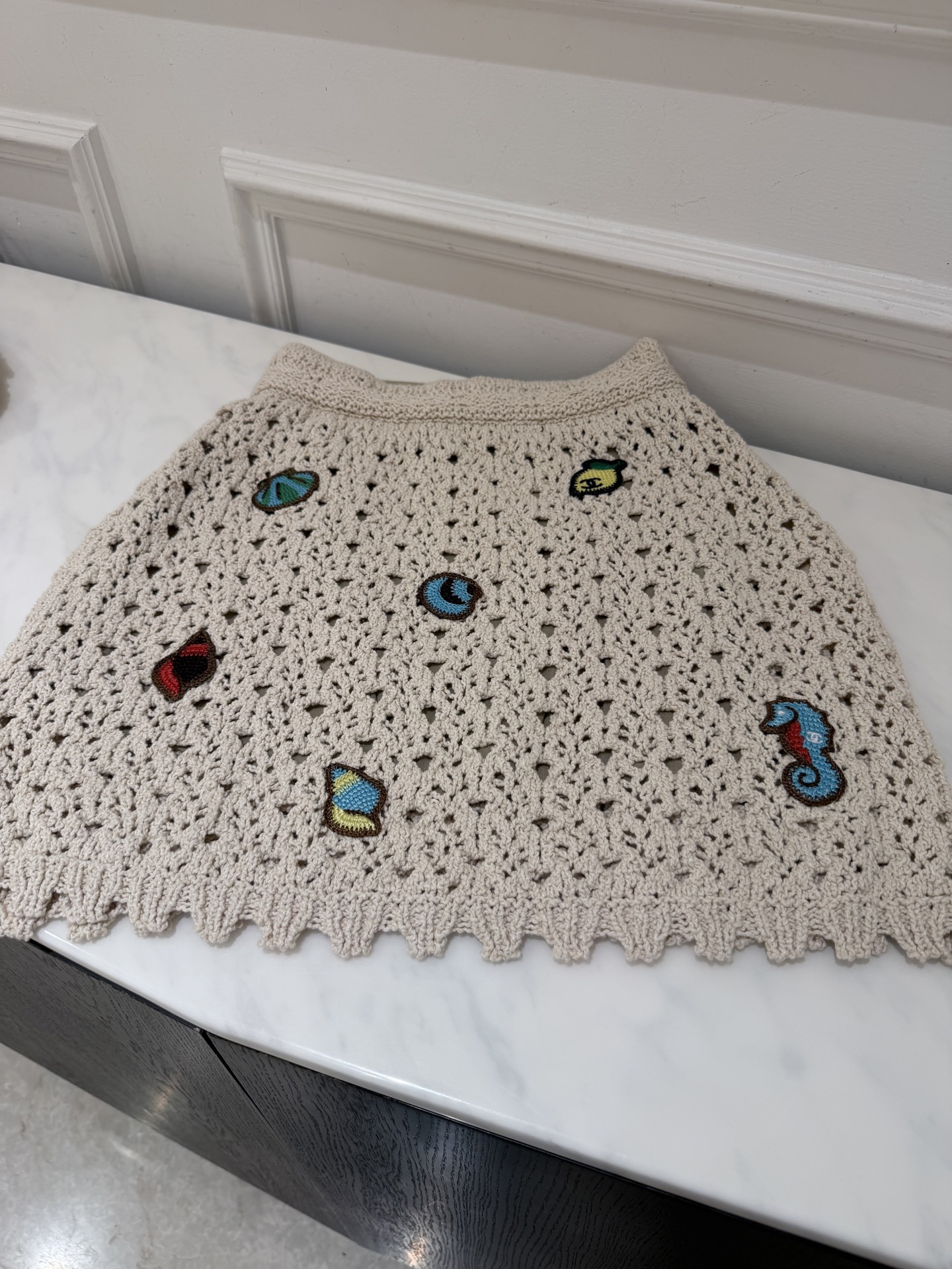 NO:857863,Cha*26M marine crochet Polo shirt. Creamy white hollow crochet, light and breathable. The Polo collar + ruffle design is super recognizable. The body is embellished with marine embroidery such as clown fish, seahorses, and shells. It is full of childlike fun and full of holiday atmosphere! Pair it with a skirt or jeans of the same series to easily get a relaxed summer look. SML skirt, Chanel-clothing, chanel, skirts, jeans,19860909Cha*26M海洋钩针Polo衫 奶油白镂空钩织,轻盈透气,Polo领+荷叶边设计超有辨识度.衣身点缀小丑鱼,海马,贝壳等海洋刺绣,童趣满满,度假氛围感拉满!搭配同系列半裙或牛仔裤,轻松 get夏日松弛感穿搭.SML 半裙,香奈儿-服装,chanel,skirts,jeans,,Women's clothing