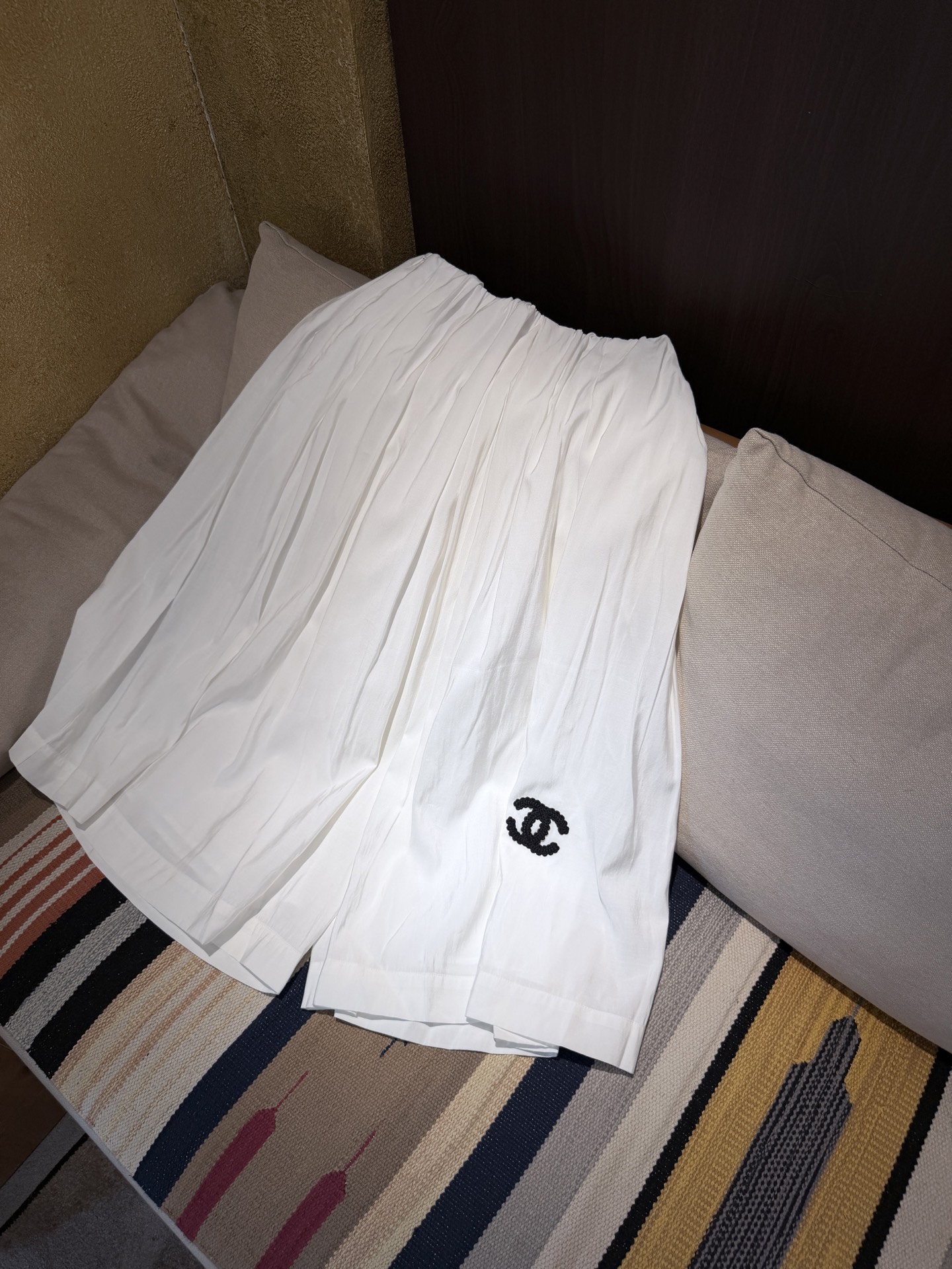 NO:860324,Cha* white pleated culottes. These white pleated culottes are made of light and breathable fabric, super comfortable to wear in summer!  The elastic waist design makes it easy to put on and take off and fits well, and the pleated technology adds a full sense of layering. There is a classic double C embroidery on the left side of the trousers, which is low-key and recognizable. It can be easily used for daily leisure and vacation. It goes well with T-shirts or shirts. It is comfortable and fashionable. It is a must-have item in the summer wardrobe!  SML.P, Chanel-clothing,chanel,skirts,shirts,tees,t-shirt,19860909Cha*白色百褶裙裤 这款白色百褶裙裤,轻薄透气面料,夏天穿超舒服！松紧腰设计,穿脱方便又贴合,百褶工艺让层次感满满.裤脚左侧有经典双C刺绣,低调又有辨识度.日常休闲、度假都能轻松驾驭,搭配T恤或衬衫都很OK,舒适又时髦,是夏日衣橱必备单品！ SML.P,香奈儿-服装,chanel,skirts,shirts,tees，t-shirt,,Women's clothing