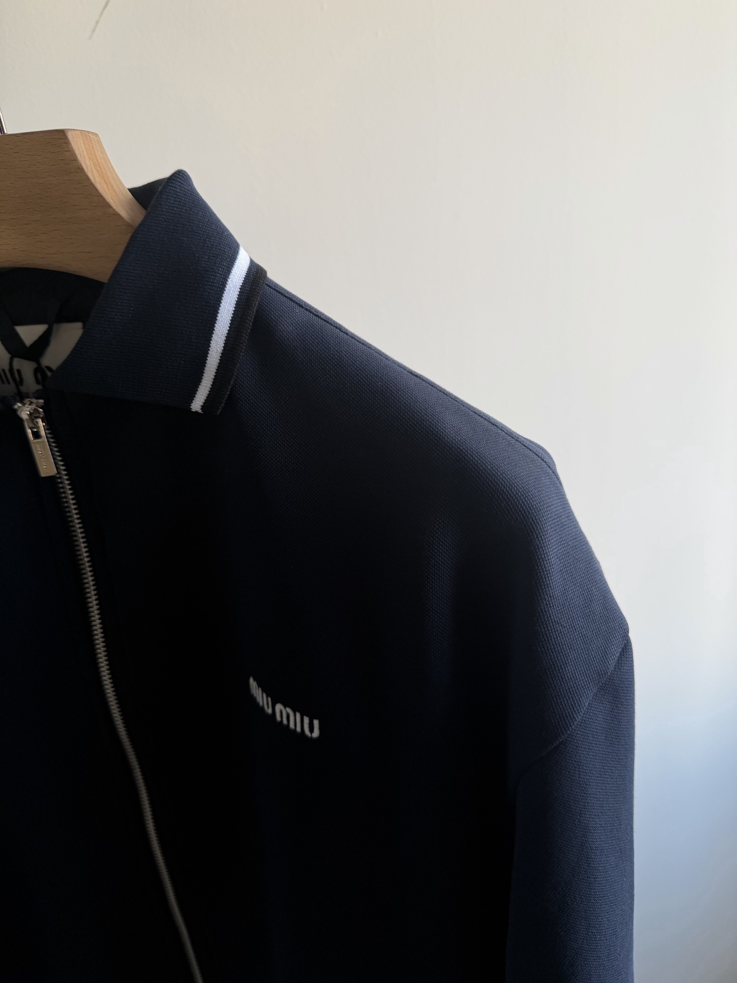 248💰（编号0031）
缪缪｜MIU MIU 25走秀款 徽标字母logo刺绣 男女款撞色针织领拉链夹克外套.
颜色：藏青色.
面料：棉 氨纶 锦纶面料.
工艺：刺绣.
尺码：S M L XL.
版型：直筒
尺码表：
S    胸围118  肩宽54 衣长66
建议：90-115斤
M   胸围122  肩宽56 衣长68
建议：115-140斤
L    胸围126  肩宽57 衣长70
建议：140-165斤
XL  胸围130  肩宽59 衣长72
建议：165-190斤