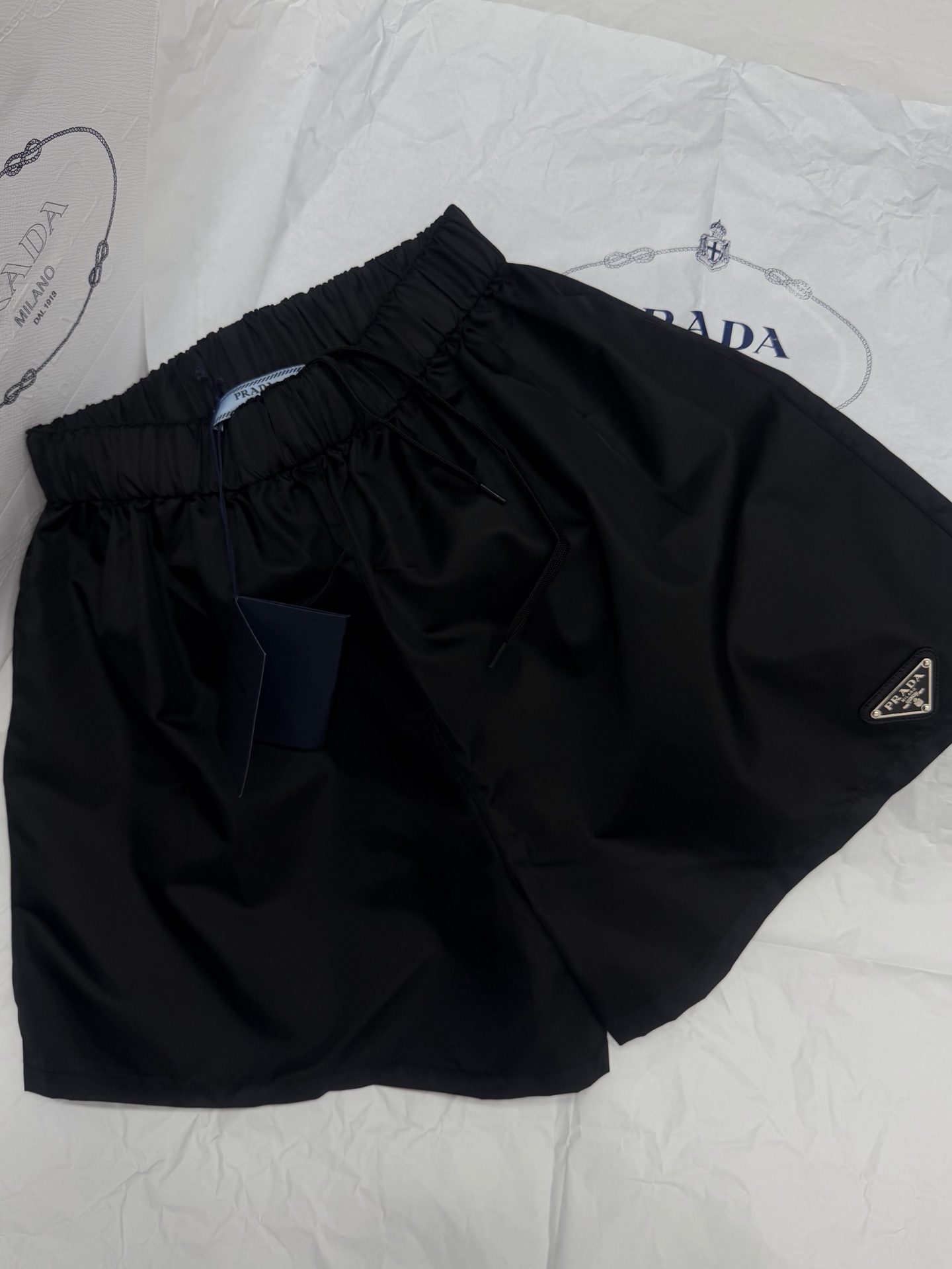 NO:802424,Original development~~ Prada black nylon shorts are made of lightweight regenerated nylon, which is environmentally friendly and durable. The elastic waist + drawstring design is comfortable and practical. The triangular metal logo on the left is very recognizable. The A-line shape is slim and versatile. It looks great with a T-shirt or a vest. It is a must-have classic item in the wardrobe!  SML detailed pictures, real shots, prada, shorts, tees, t-shirts,19860909原版开发～～ Prada黑色尼龙短裤采用轻薄再生尼龙,环保又耐用 松紧腰+束绳设计,舒适又实穿 左侧三角金属徽标超有辨识度,A字版型显瘦又百搭,无论配T恤还是背心都很出彩,是衣橱必备经典单品！SML细节图实拍,,prada,shorts,tees，t-shirt,,Women's clothing