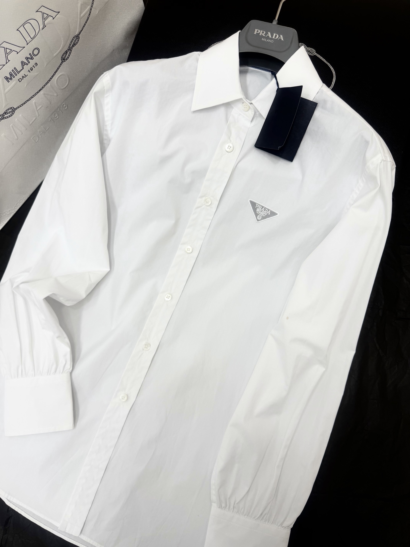 NO:800227,Original development~~ 26ss Logo embroidered shirt. The white shirt has classic inverted triangle metal embroidery on the chest, which is low-key and recognizable. High-quality cotton material, soft and breathable, super comfortable to wear~ The shape is crisp, the cuffs are adjustable, and the details are perfect. It can be easily controlled whether it is commuting or leisure. It can be worn alone or layered, simple and fashionable. SML detailed pictures, shirts,19860909原版开发～～ 26ss Logo刺绣衬衫 白衬衫胸前有经典倒三角金属刺绣,低调又有辨识度.高品质棉料,柔软透气,穿着超舒适～版型挺括,袖口可调节,细节满分.无论通勤还是休闲都能轻松驾驭,单穿or叠穿都OK,简约又时髦 SML细节图实拍,,shirts,,Women's clothing