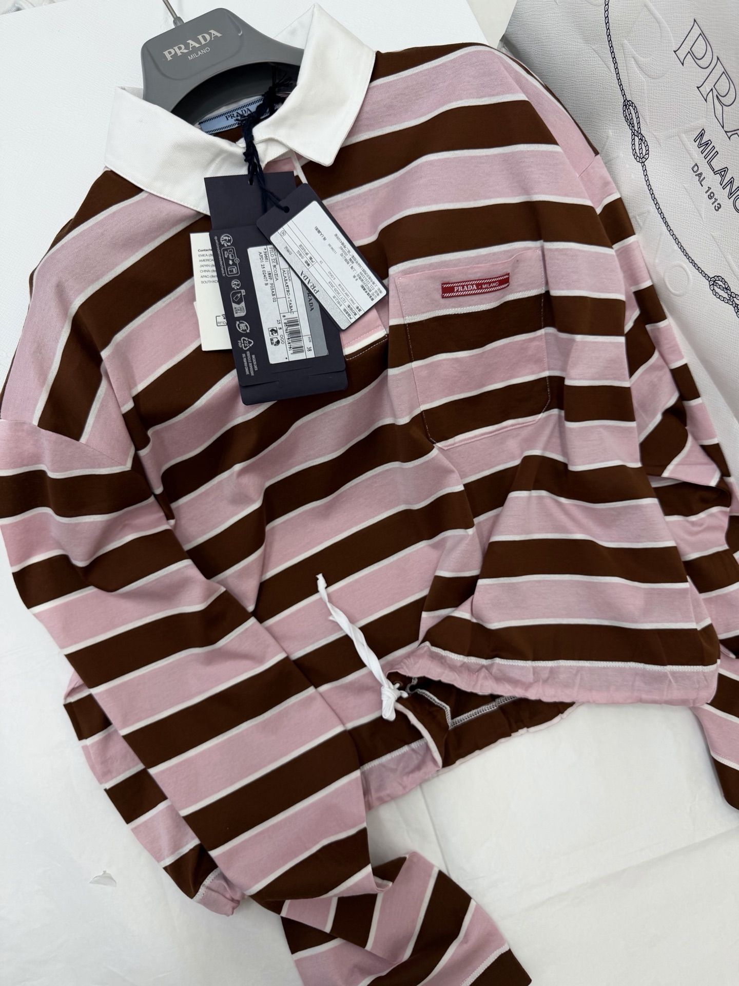 NO:802437,Authentic real shot ~ original development ~ 26ss pink and brown striped Polo shirt with classic lapel + loose fit, soft and comfortable cotton fabric, super friendly for daily wear!  Pink and brown stripes with white collar, small chest pocket + brand woven label, perfect details. Retro college style. Pair it with a work skirt or jeans to easily switch between sweet and cool or casual style. It is suitable for going out, commuting, and traveling in spring and autumn. It is fashionable and practical!  SML authentic details,,skirts,jeans,19860909正品实拍～原版开发~ 26ss 粉棕条纹Polo衫经典翻领+宽松版型,棉质面料柔软舒适,日常穿着超友好！粉棕条纹配白色领口,胸前小口袋+品牌织标,细节满分 复古学院风,搭配工装裙或牛仔裤,轻松切换甜酷or休闲风,春秋季节出街、通勤、旅行都很适合,时髦又实用！SML正品细节,,skirts,jeans,,Women's clothing