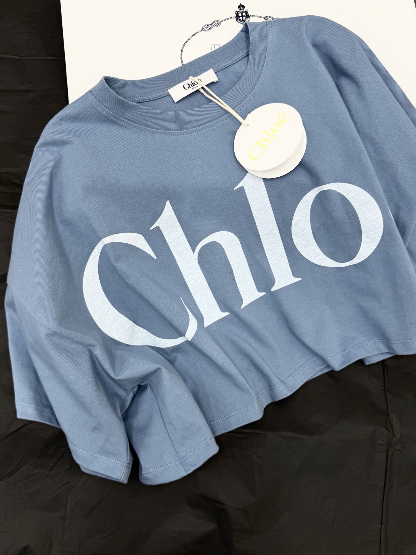 NO:822943,Original development~ The blue logo short-sleeved T-shirt is made of pure cotton, soft and comfortable, and super refreshing to wear in spring and summer!  The white 'Chloe' logo on the front is simple and recognizable. It is cut in a short version and paired with high-waisted jeans or skirts to easily create a casual fashion sense. The light blue tone is fresh and versatile, suitable for daily outings and vacations. It is a must-have item for the spring and summer wardrobe. Actual shot of SML details, chloe, loewe, skirts, jeans, T-shirt, tees, t-shirt,19860909原版开发～ 蓝色Logo短袖T恤采用纯棉材质,柔软舒适,春夏穿超清爽！正面白色“Chloe”Logo,简约又有辨识度 短版剪裁,搭配高腰牛仔裤或短裙,轻松打造随性时尚感.浅蓝色调清新百搭,日常出街、度假都很适合,是春夏季衣橱必备单品SML细节图实拍,,chloe,loewe,skirts,jeans,T-shirt,tees，t-shirt,,Women's clothing